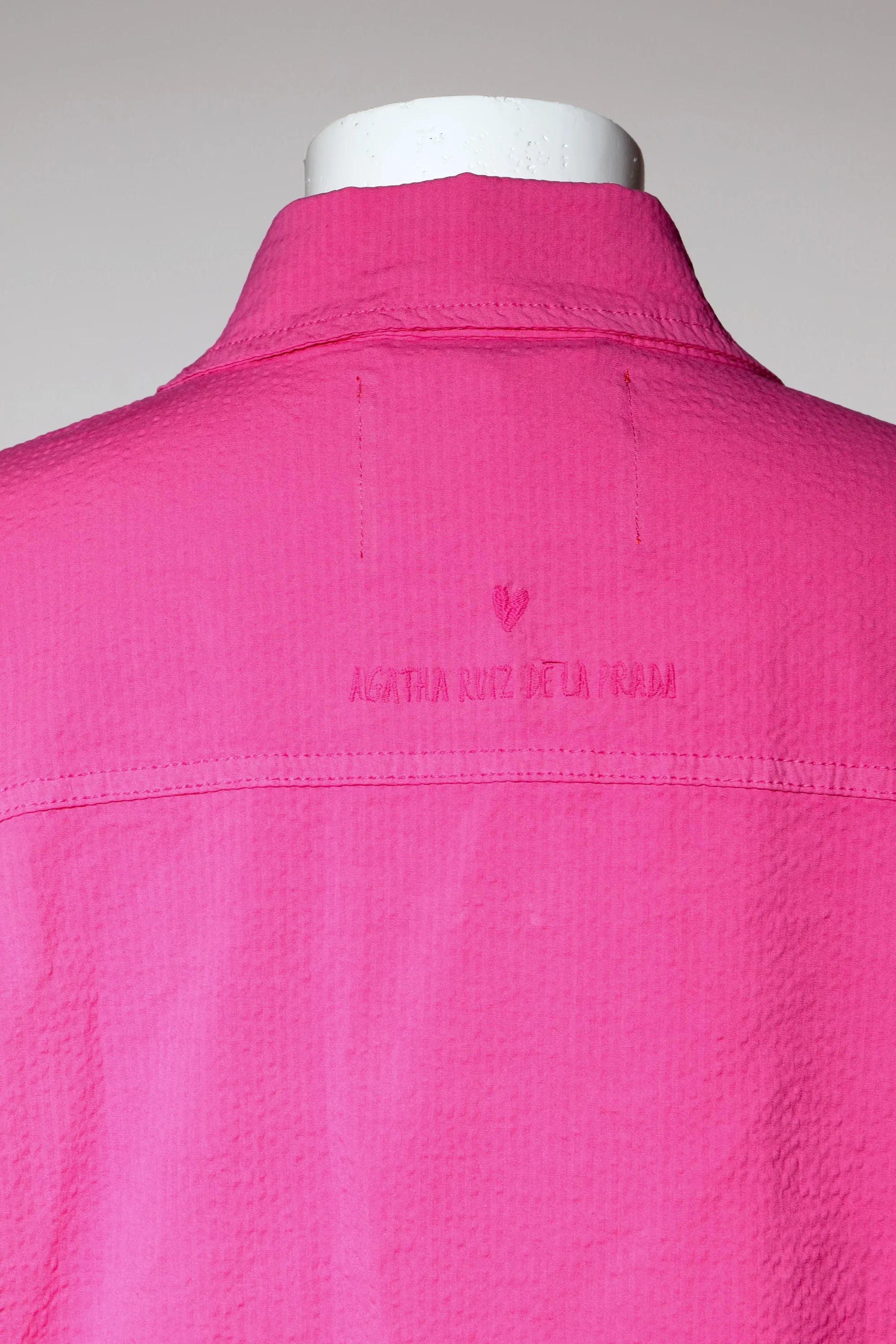 Sobrecamisa fucsia con cuello alto y bordado en la espalda, vista posterior