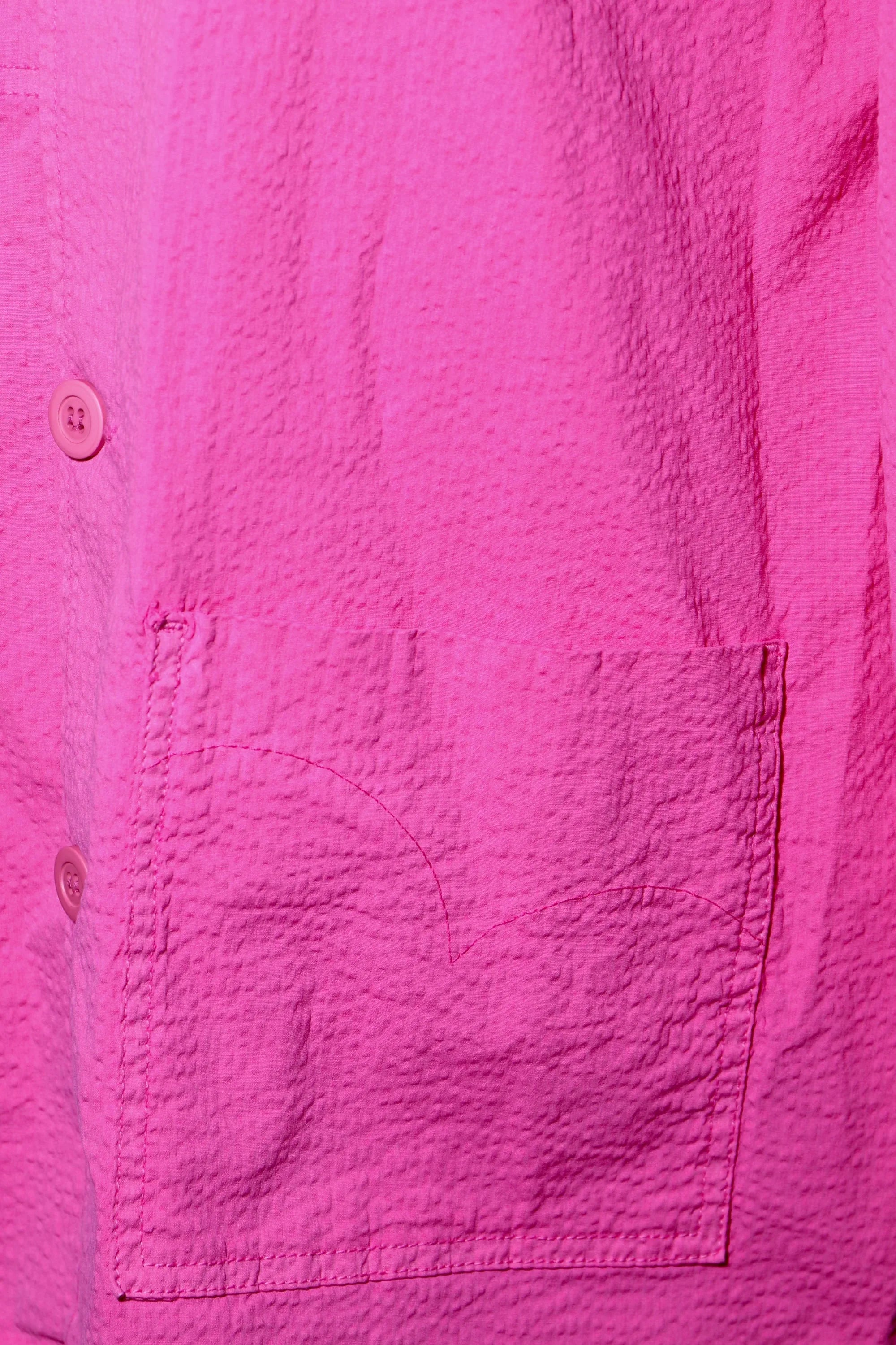 Sobrecamisa fucsia: detalle de bolsillo frontal con costuras