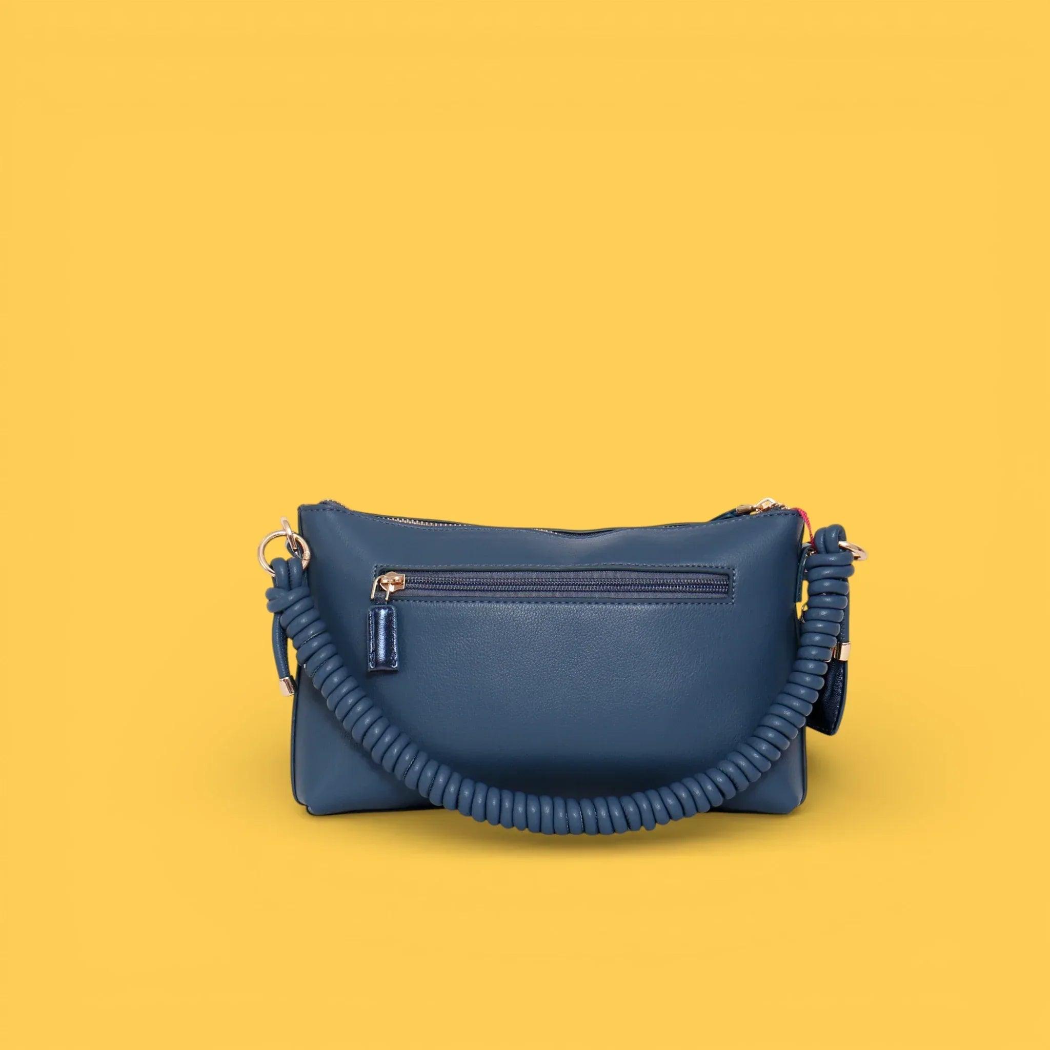Bandolera azul con bolsillo frontal, asa de cordón trenzado y cierre superior.