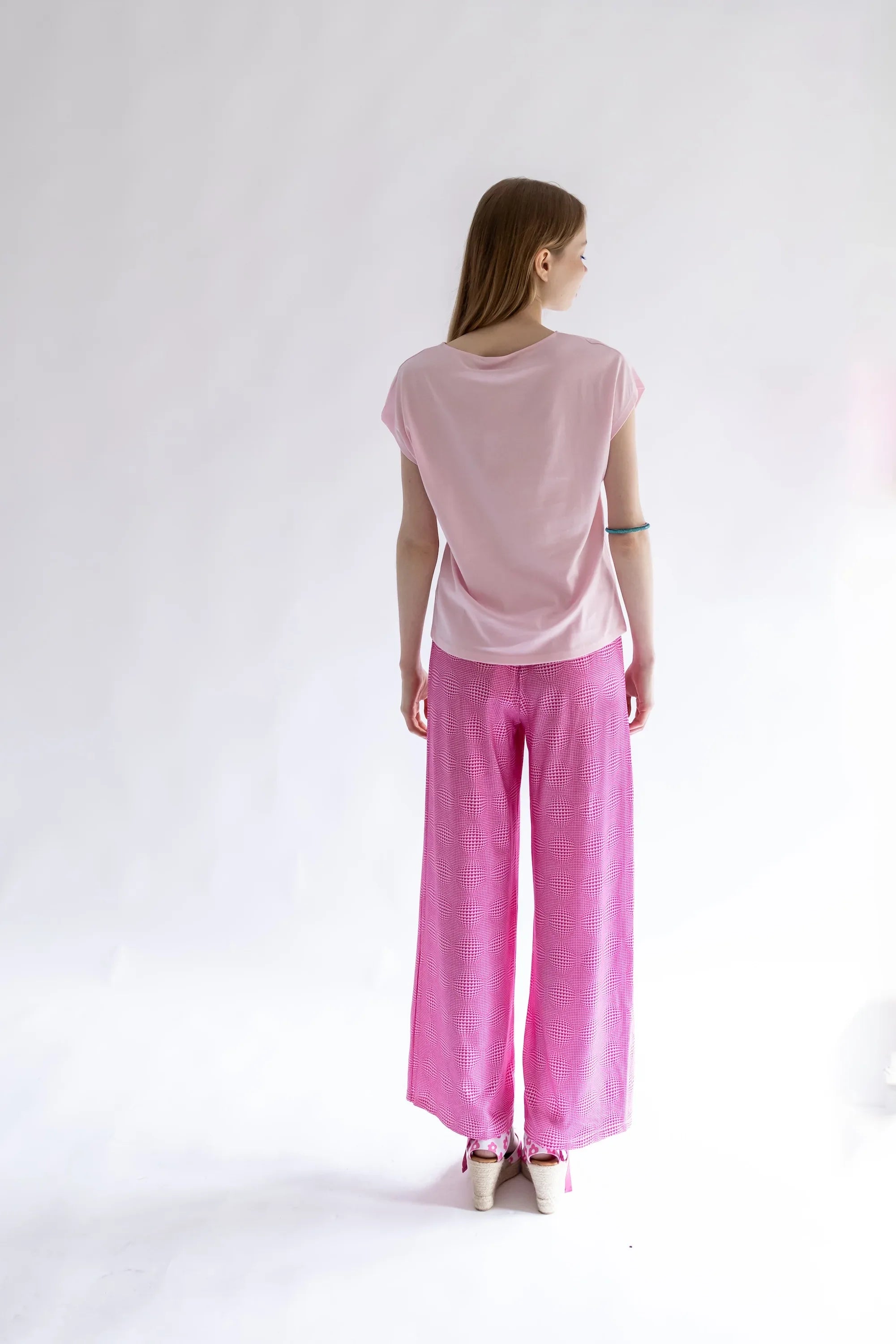 Pantalón rosa de pierna ancha con estampado de corazones; vista trasera.