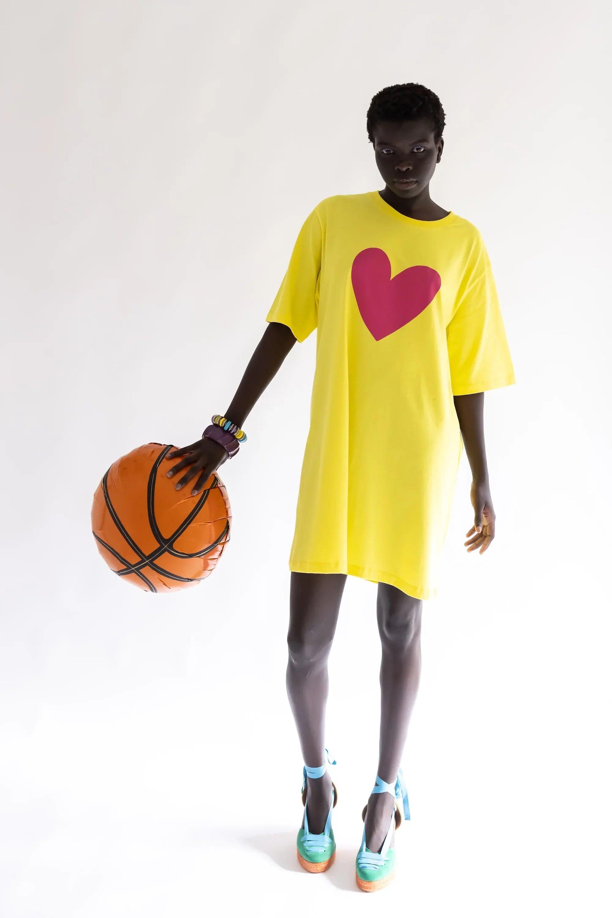 Vestido amarillo con corazón fucsia centrado, manga corta y dobladillo recto