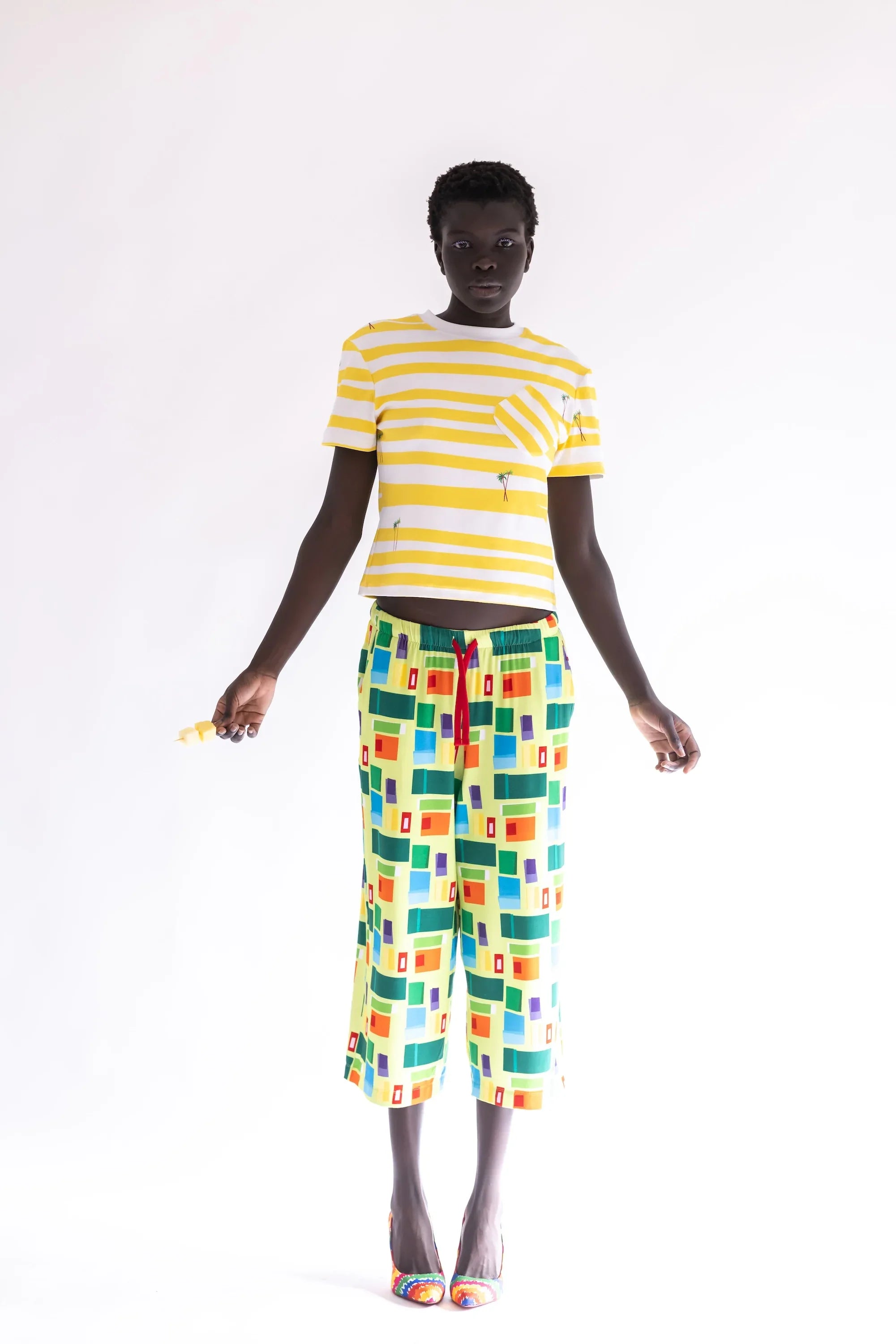 Pantalón largo estampado multicolor con cuadros, vista frontal completa y corte suelto.