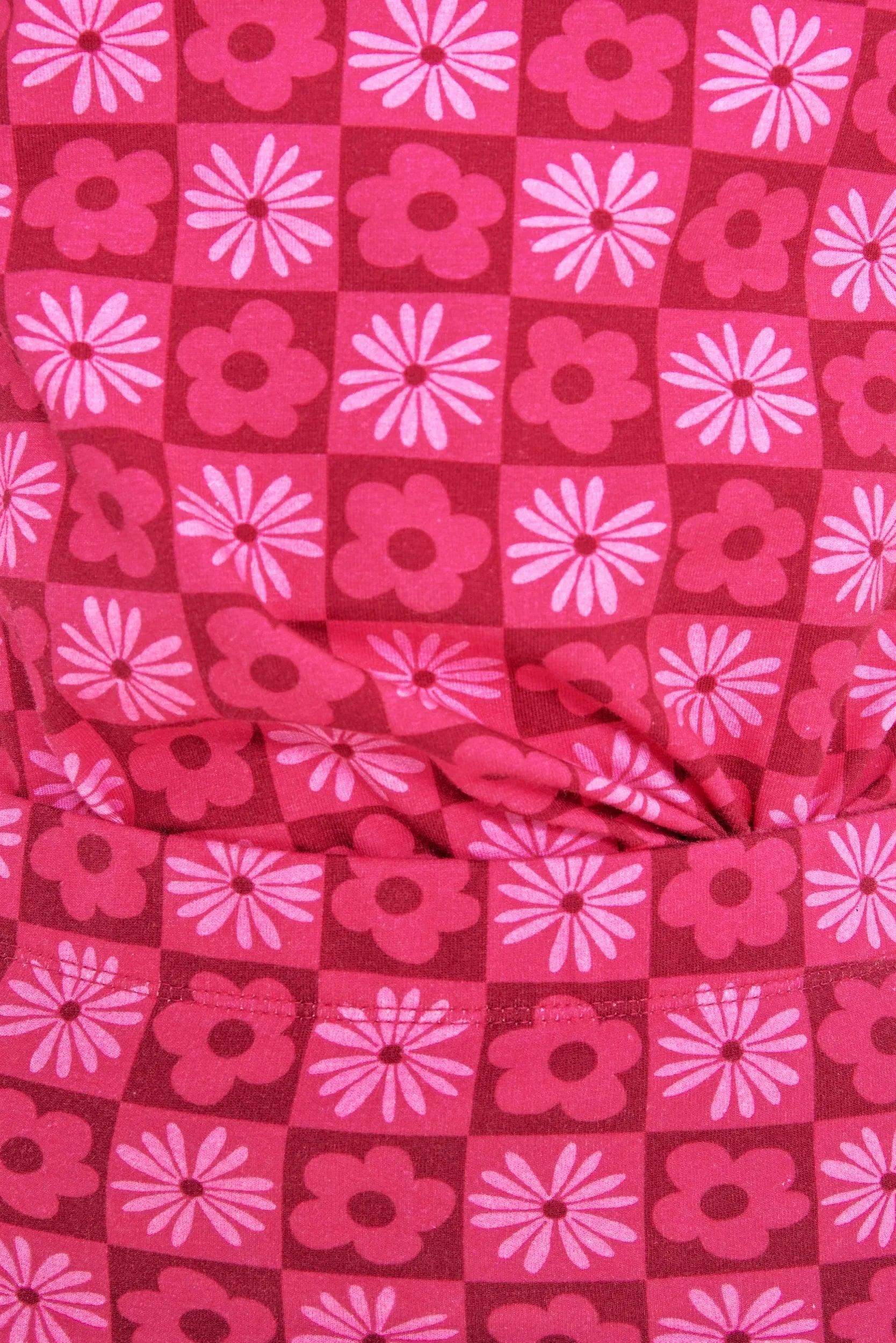 Tela de falda fucsia con patrón cuadrado de flores geométricas