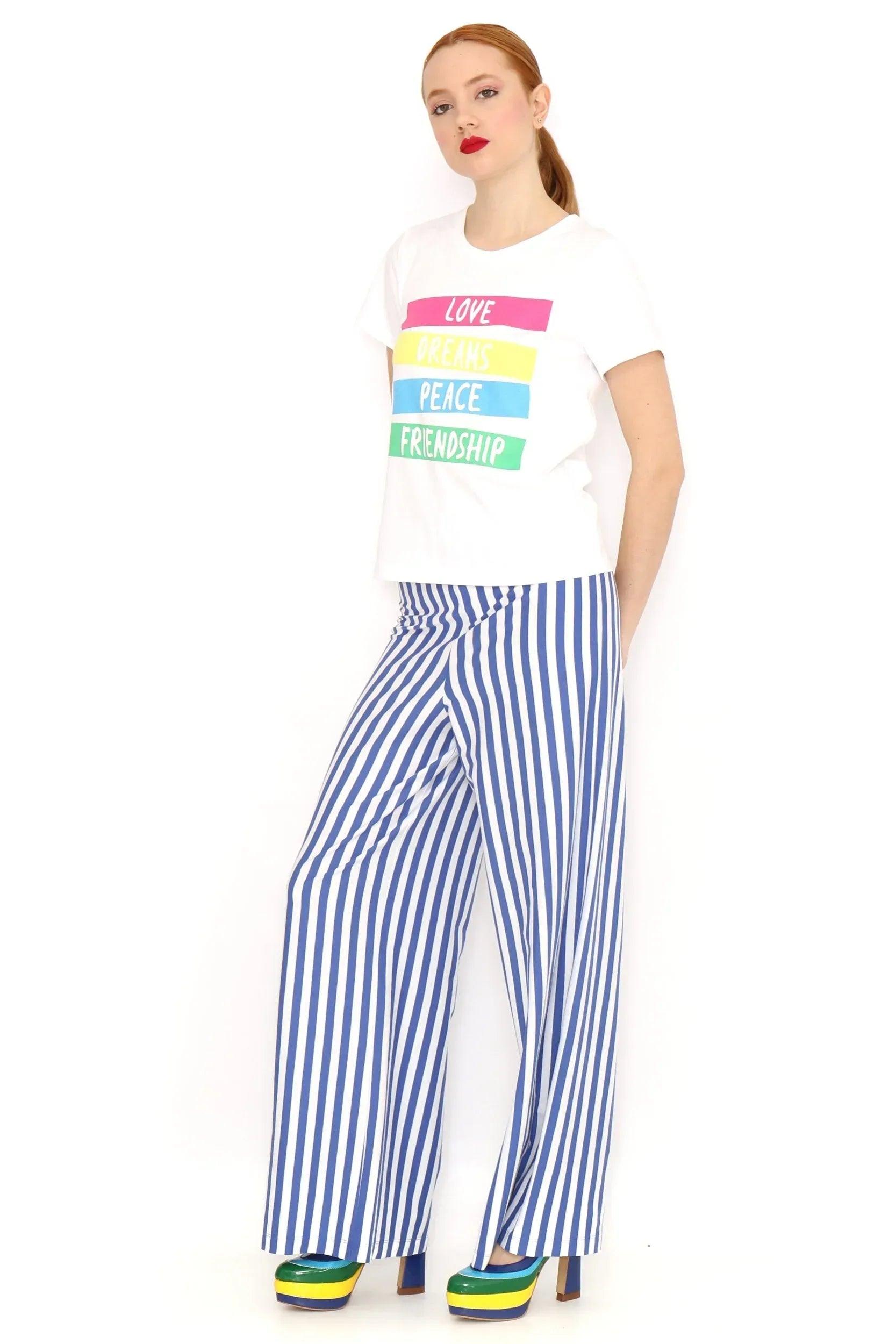 Camiseta blanca con franjas de colores y texto LOVE DREAMS PEACE FRIENDSHIP