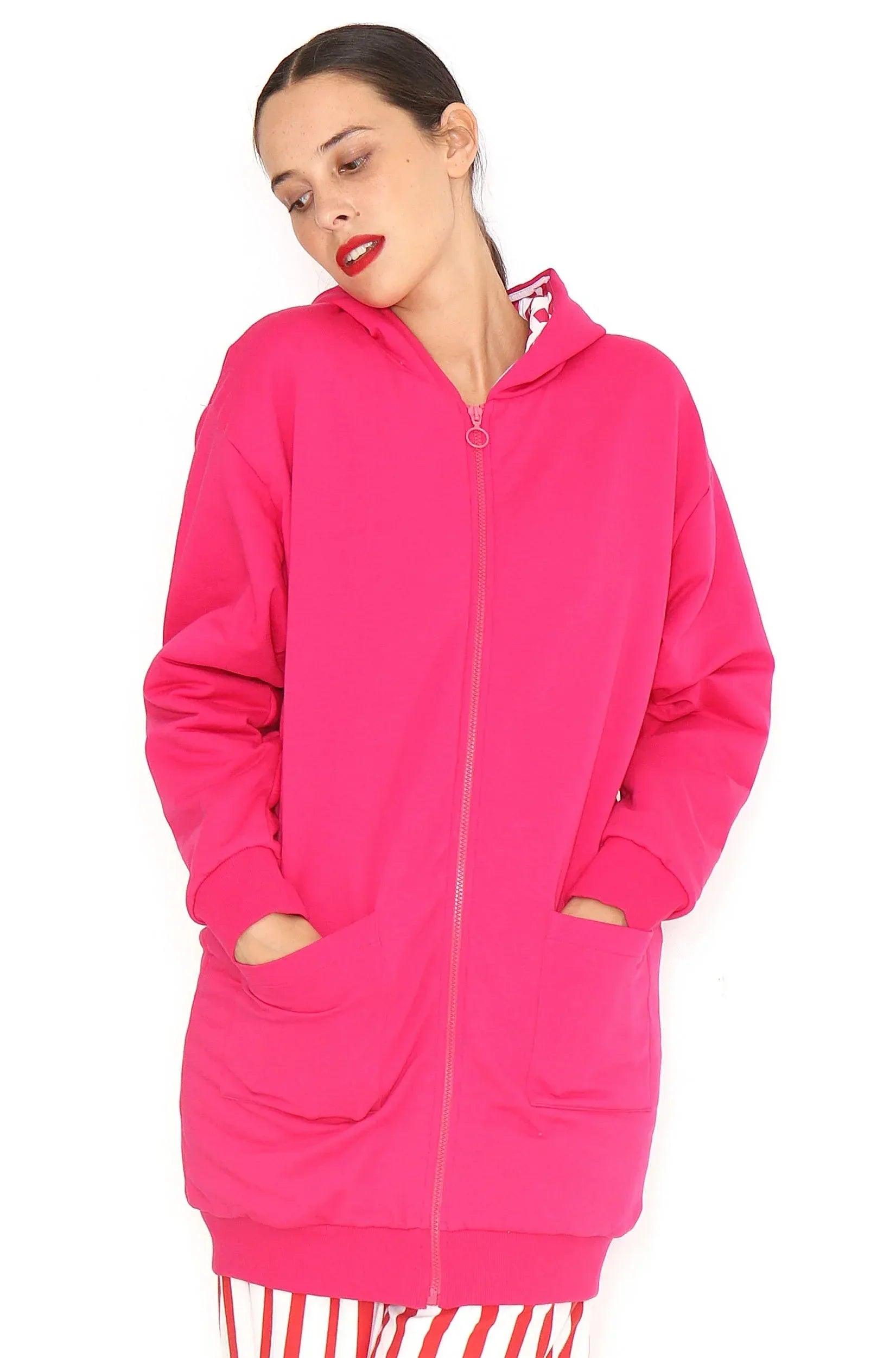 Chaqueta larga fucsia con capucha, cierre frontal y bolsillos laterales.