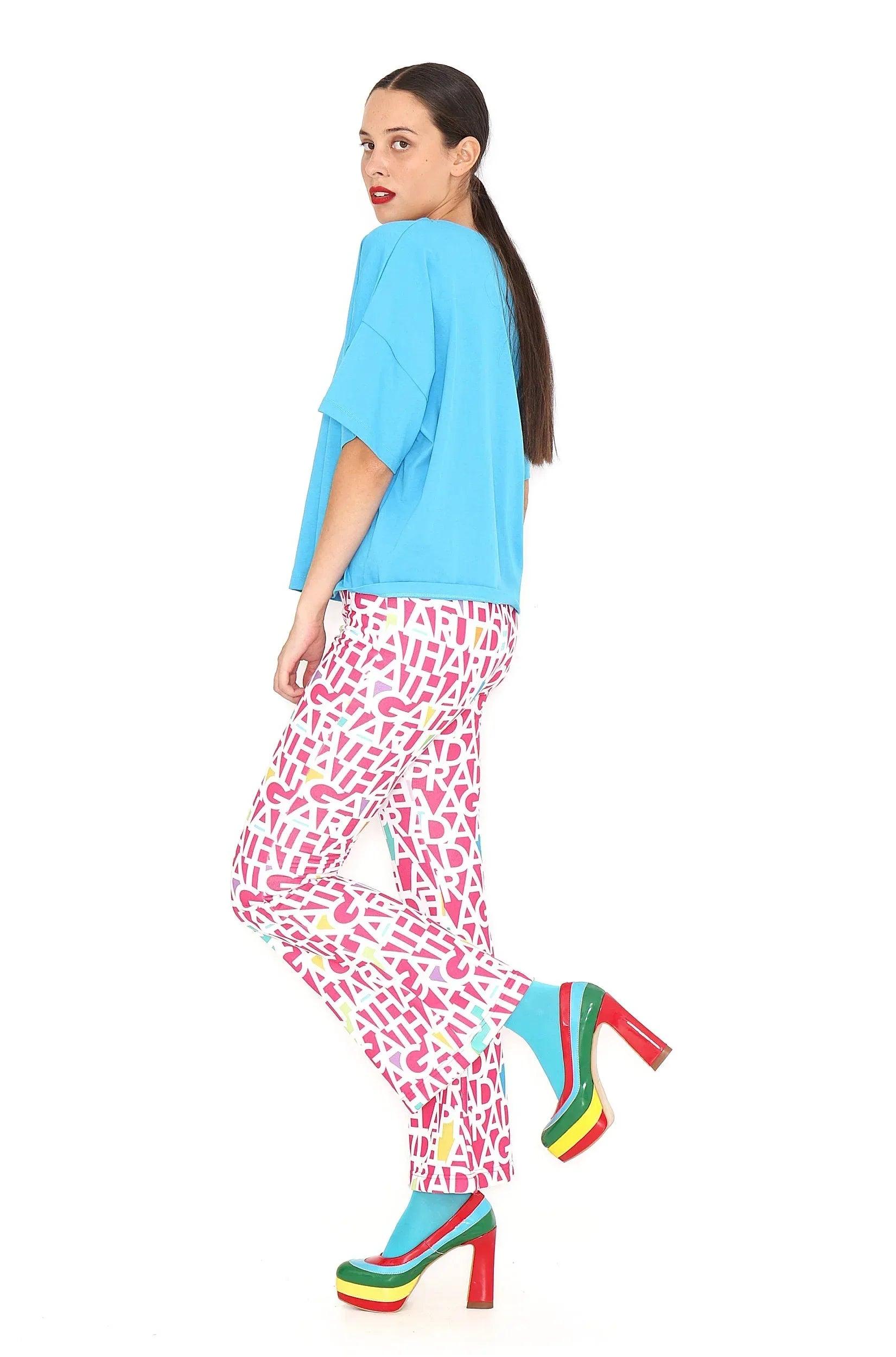 Pantalón fucsia con letras blancas repetidas, pierna recta.