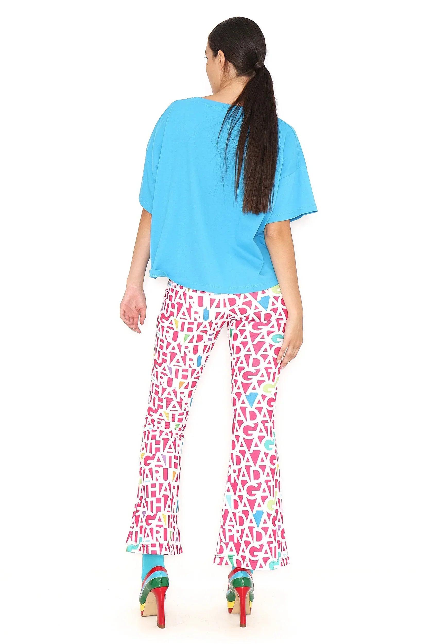 Pantalón fucsia con letras blancas repetidas, vista trasera completa.