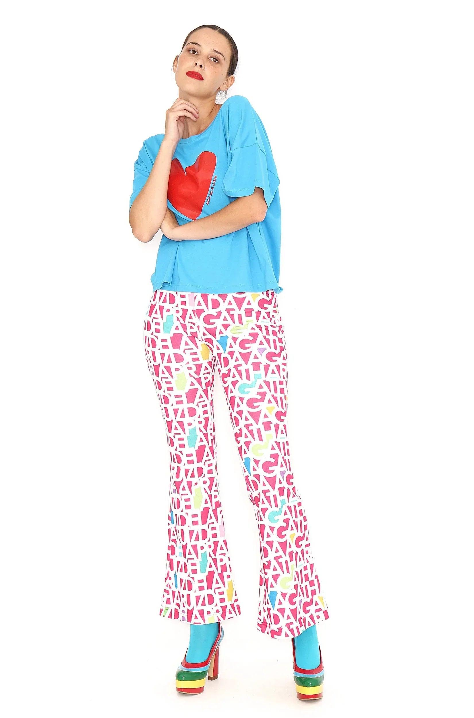Pantalón fucsia con patrón de letras blancas, corte recto y ancho.