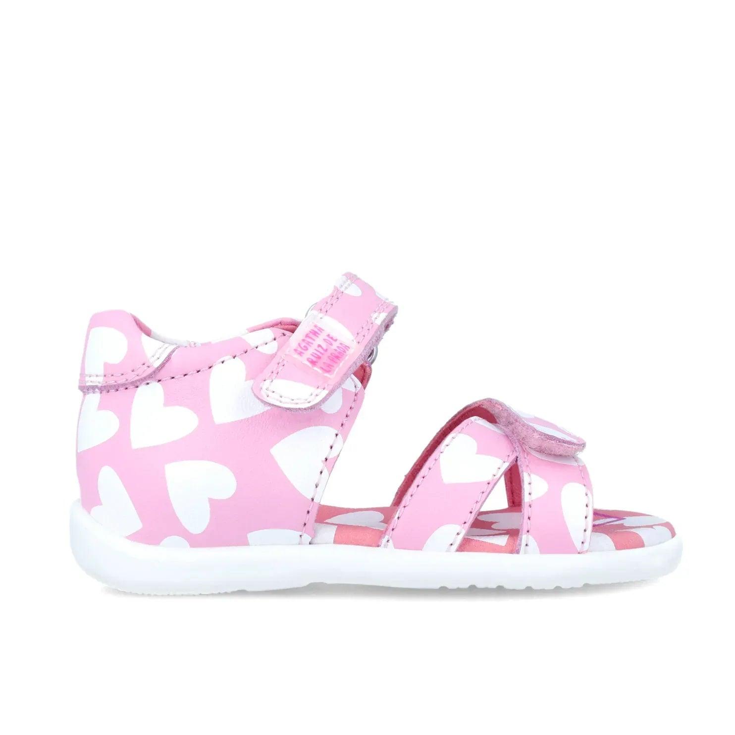 Sandalia rosa con estampado de corazones blancos, diseño abierto y suela acolchada.