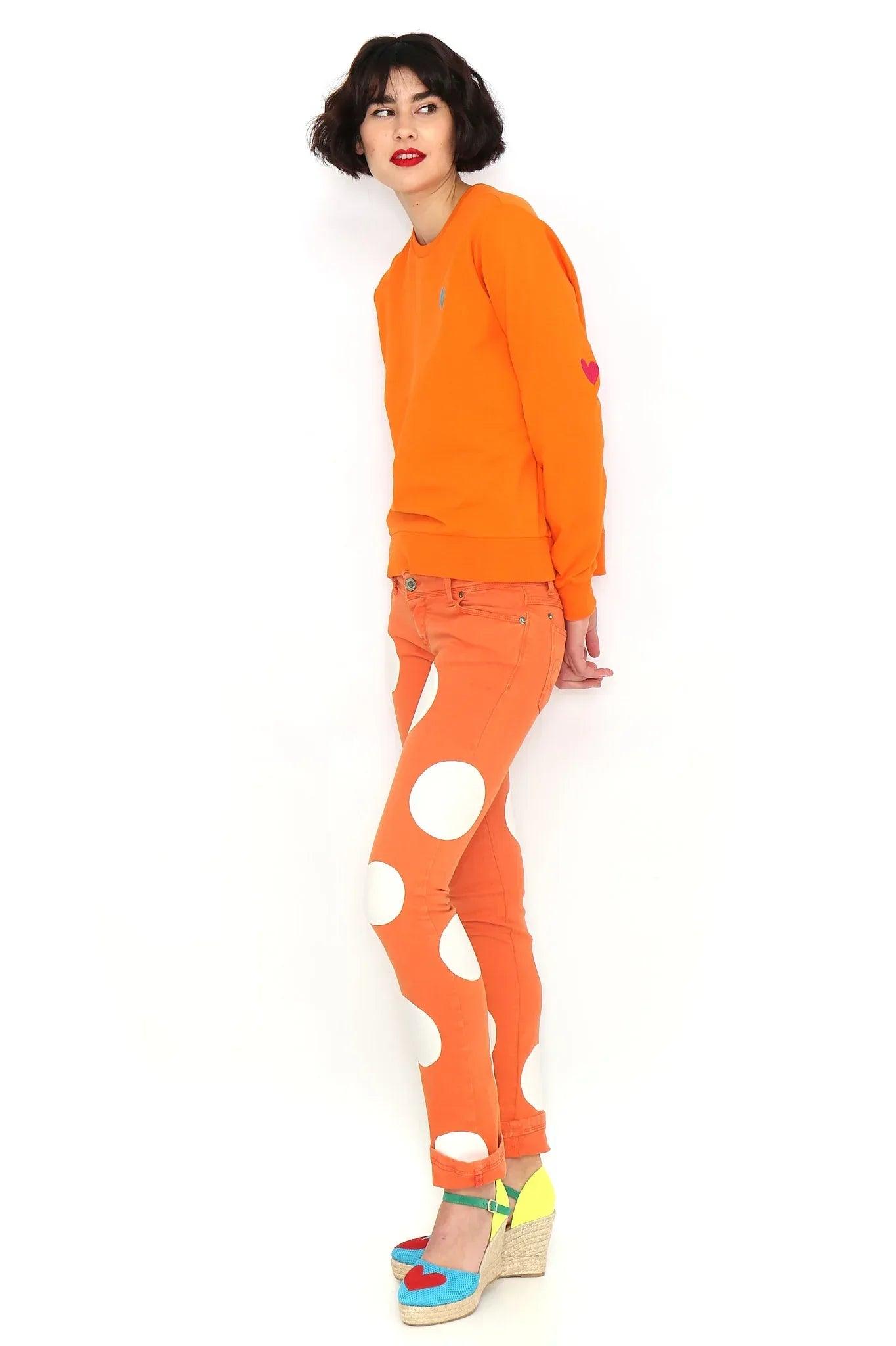 Sudadera naranja básica de manga larga con pequeño corazón azul en el pecho.