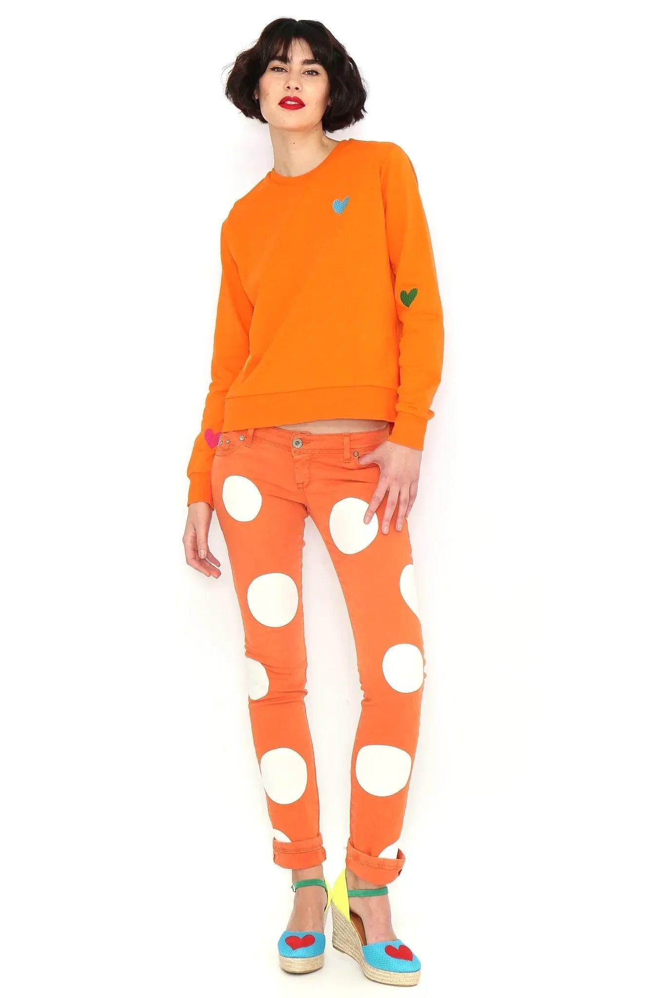 Sudadera naranja básica con cuello redondo, corazón azul en el pecho y verde en la manga.