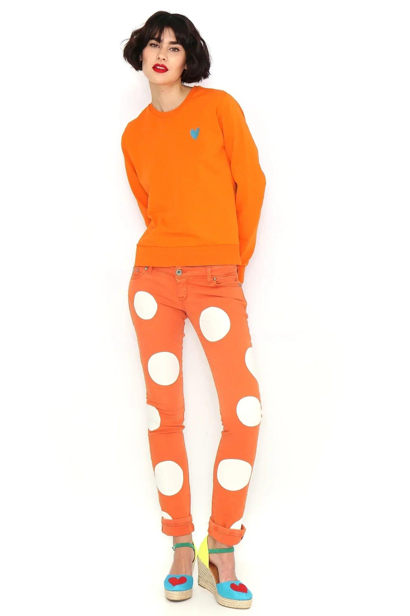 Sudadera naranja básica con corazón azul en el pecho y puños acanalados.