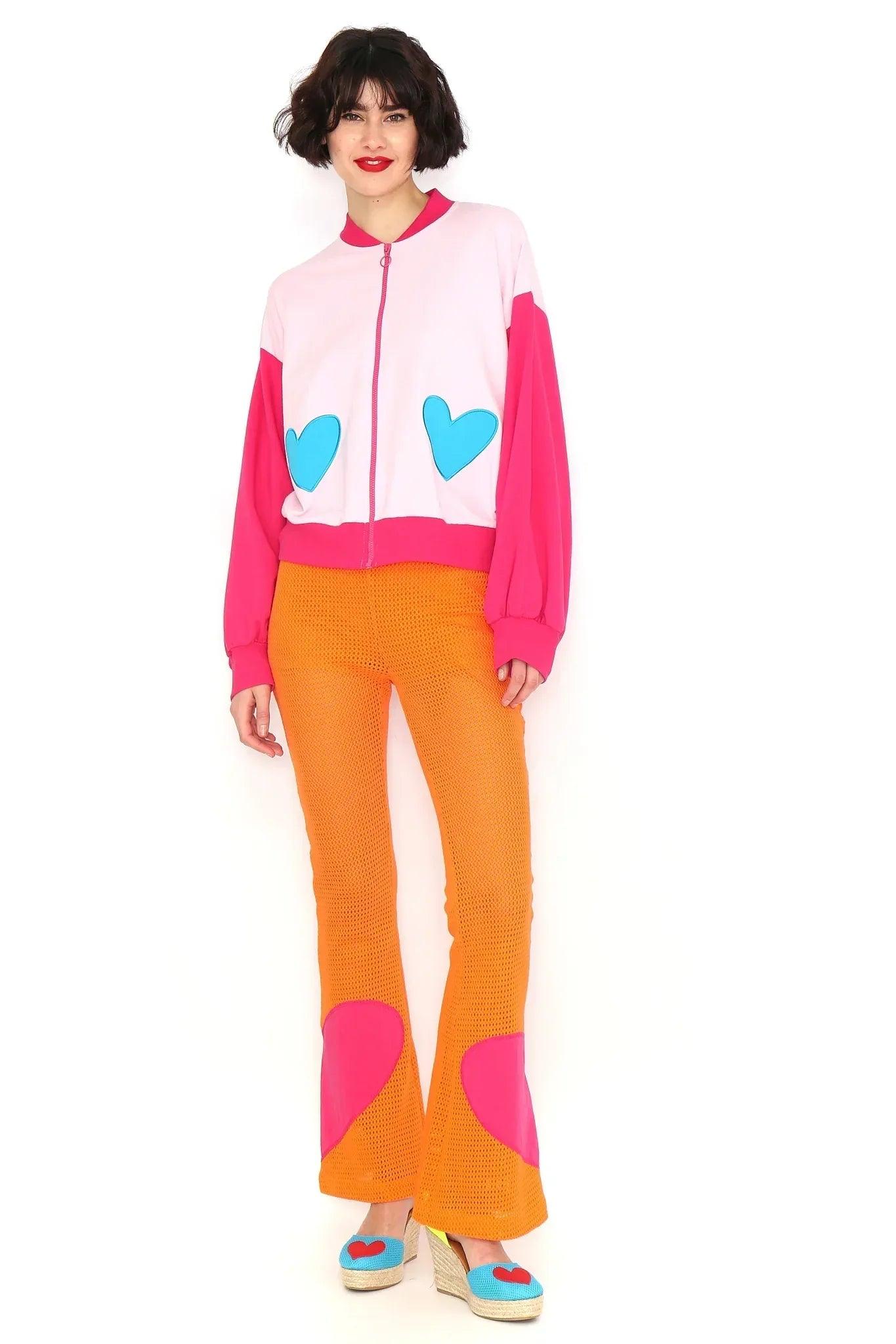 Pantalón naranja calado con parches rosa en forma de corazón y bajos acampanados