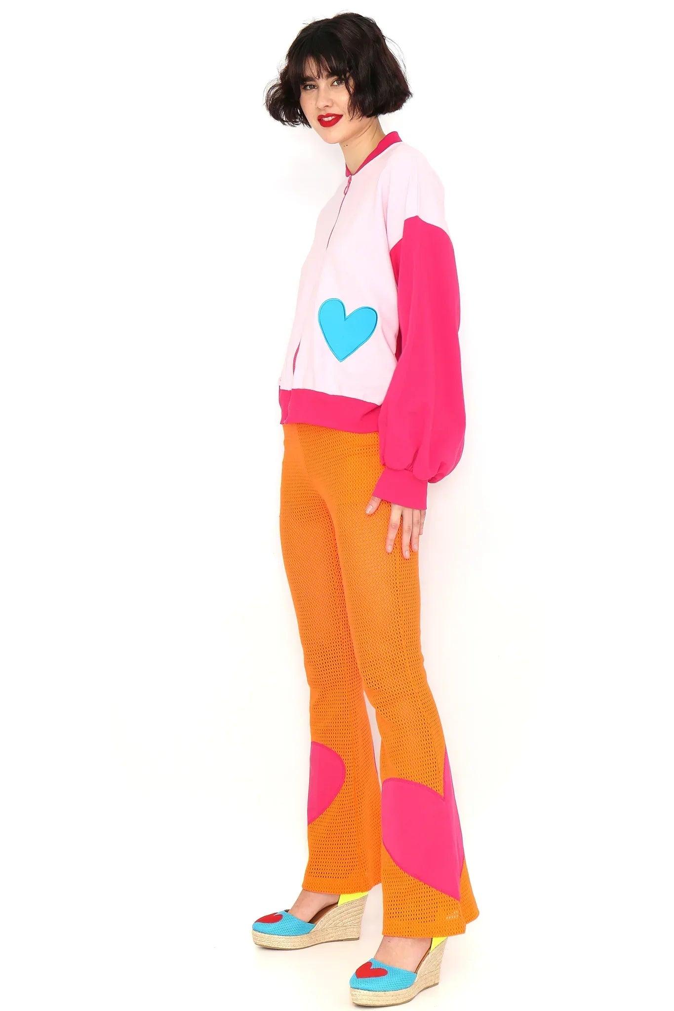 Pantalón naranja de pierna recta con calado y parches rosa en forma de corazón
