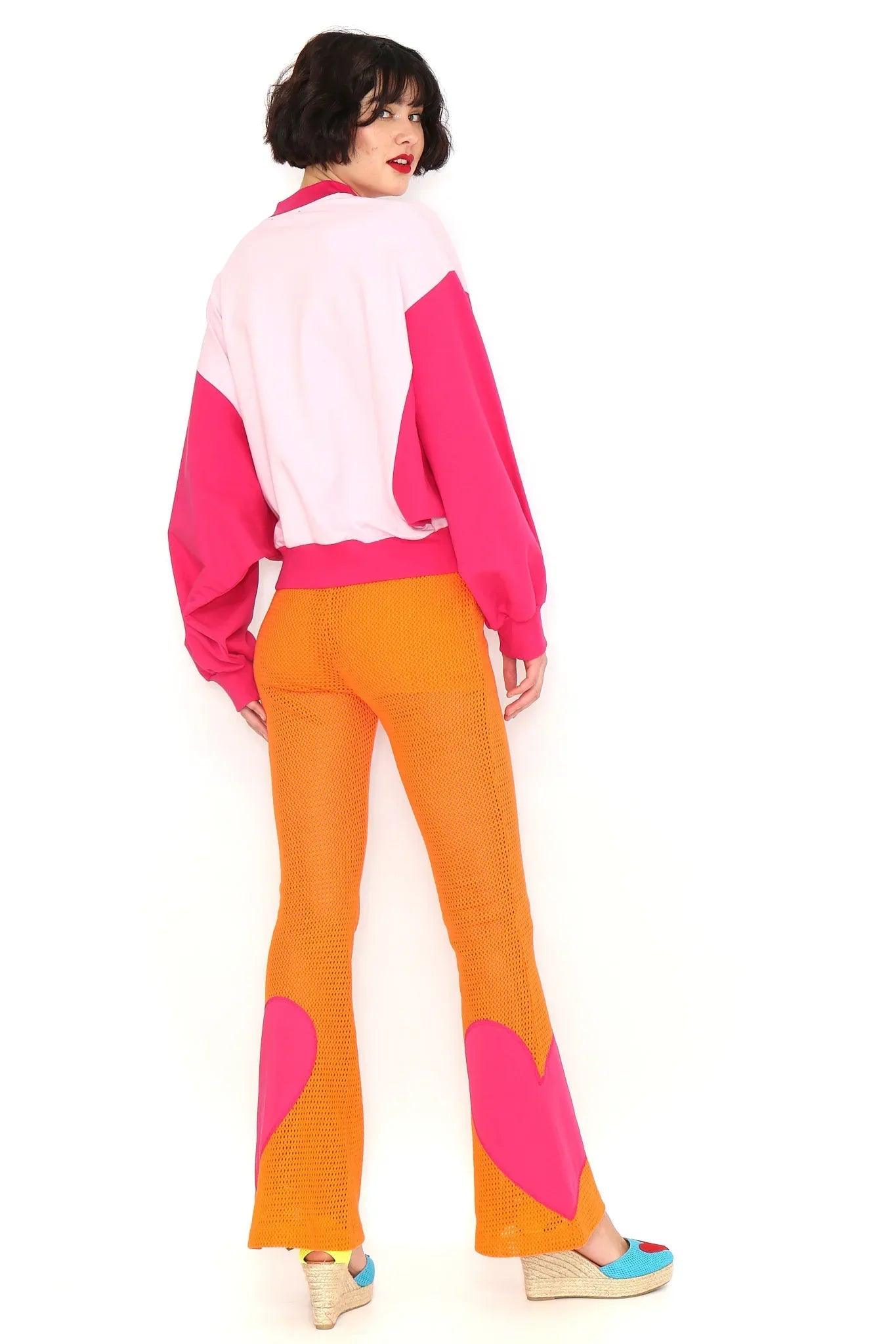 Pantalón naranja con calado y parches rosa tipo corazón en los laterales