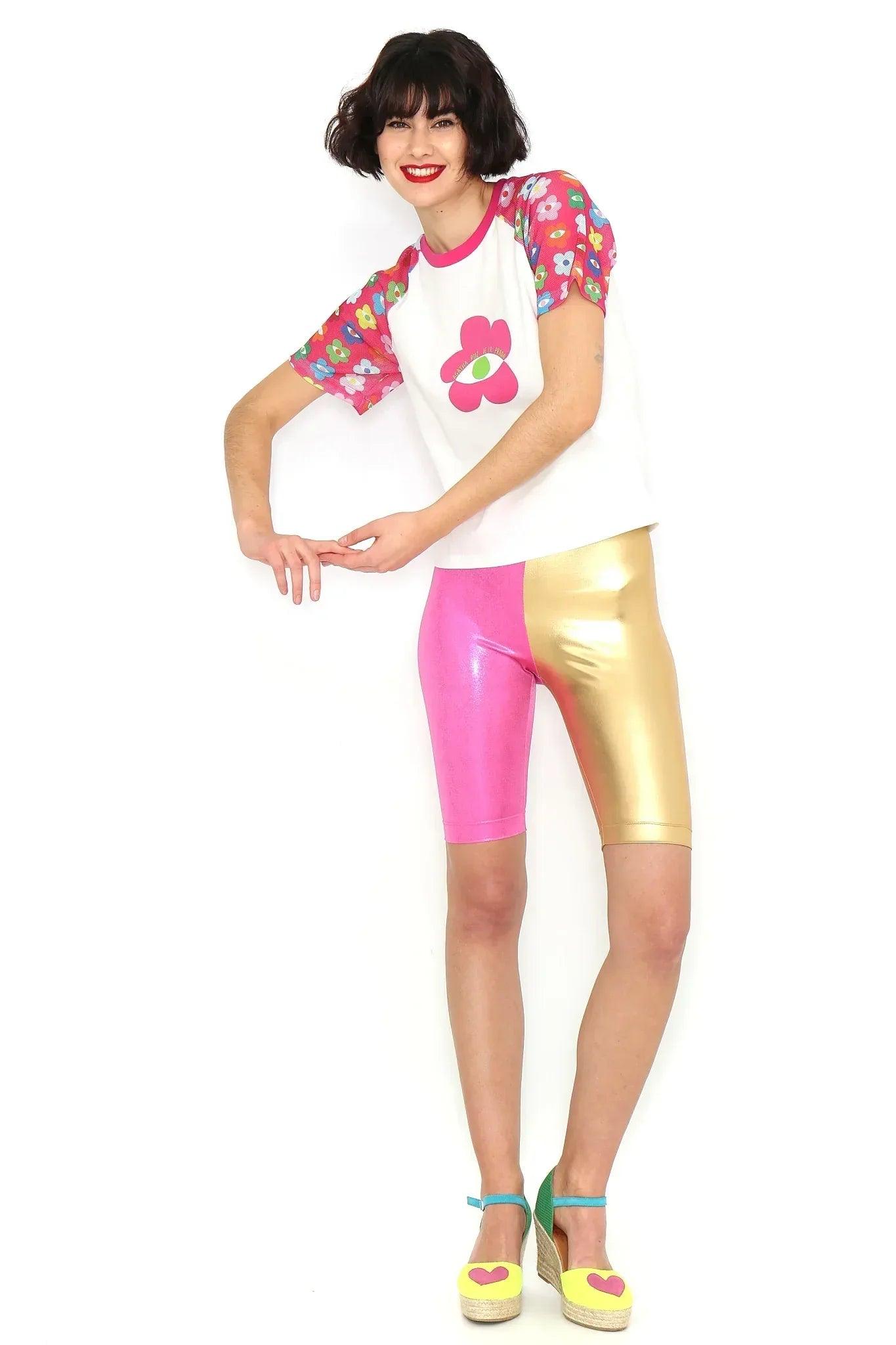 Camiseta blanca con flor fucsia y mangas estampadas, con el brazo flexionado