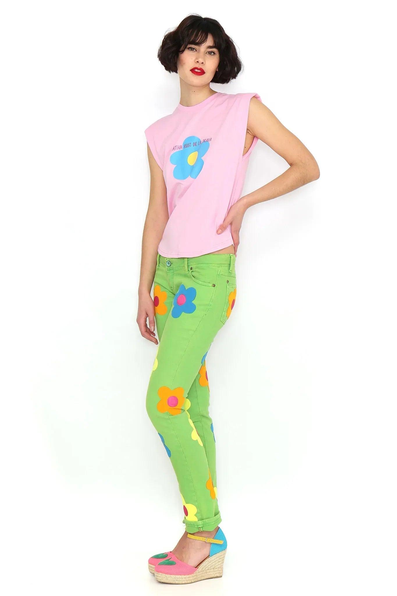 Camiseta sin mangas rosa con hombreras y flor azul frontal