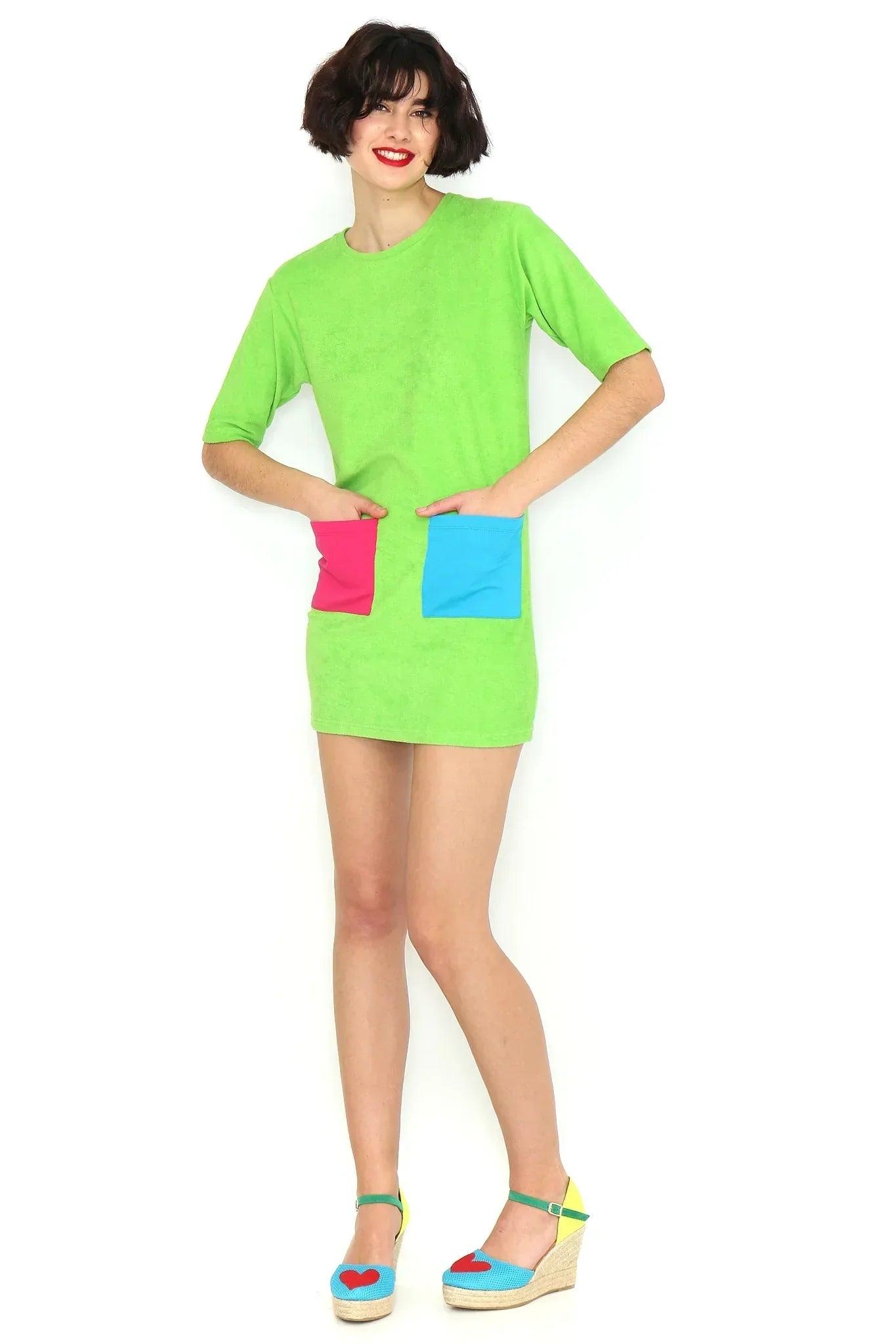 Vestido verde corto con cuello redondo, manga corta y bolsillo rectangular azul y rosa