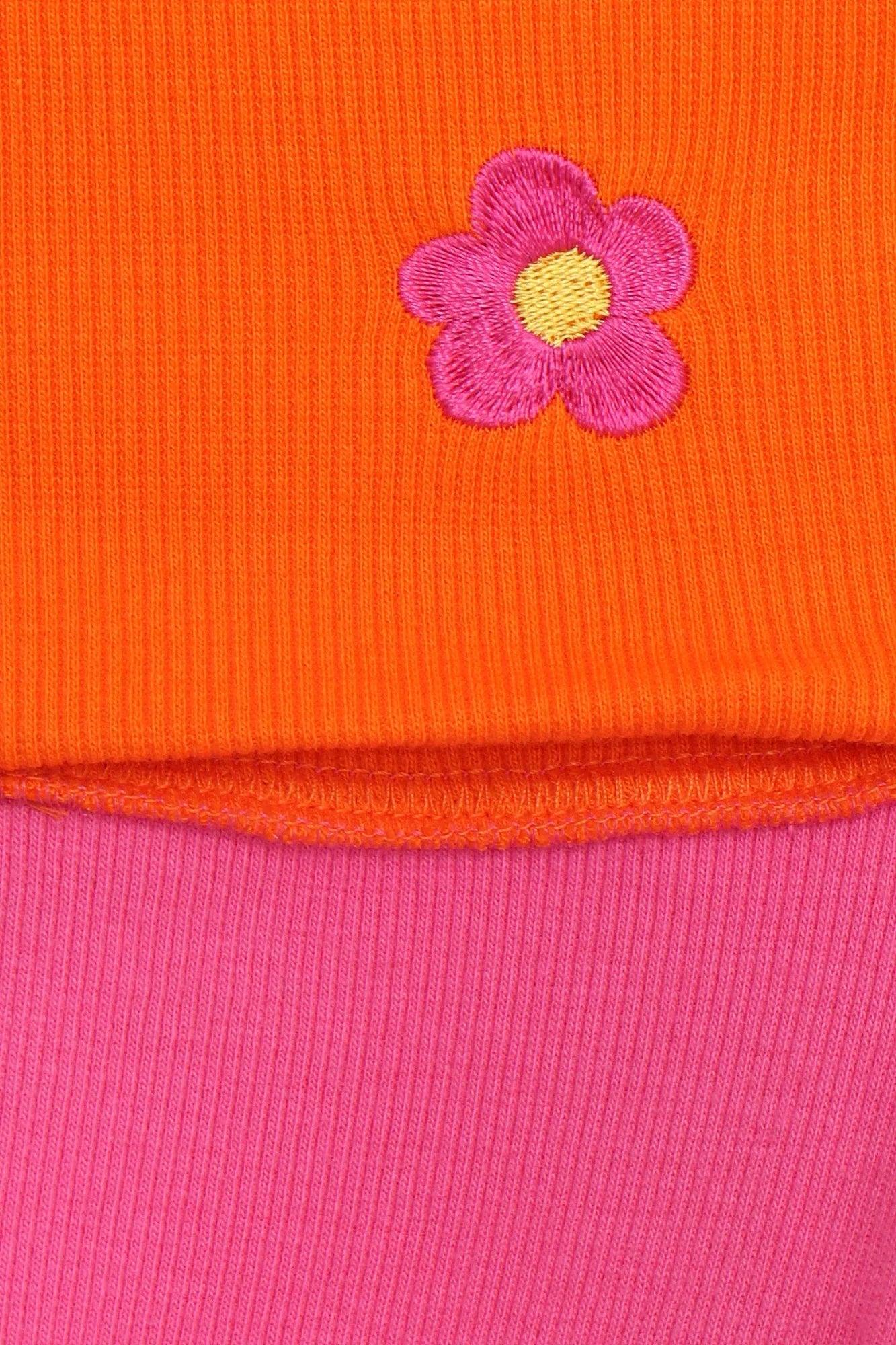 Aplicación floral en tela naranja sobre falda lápiz rosa Canale.