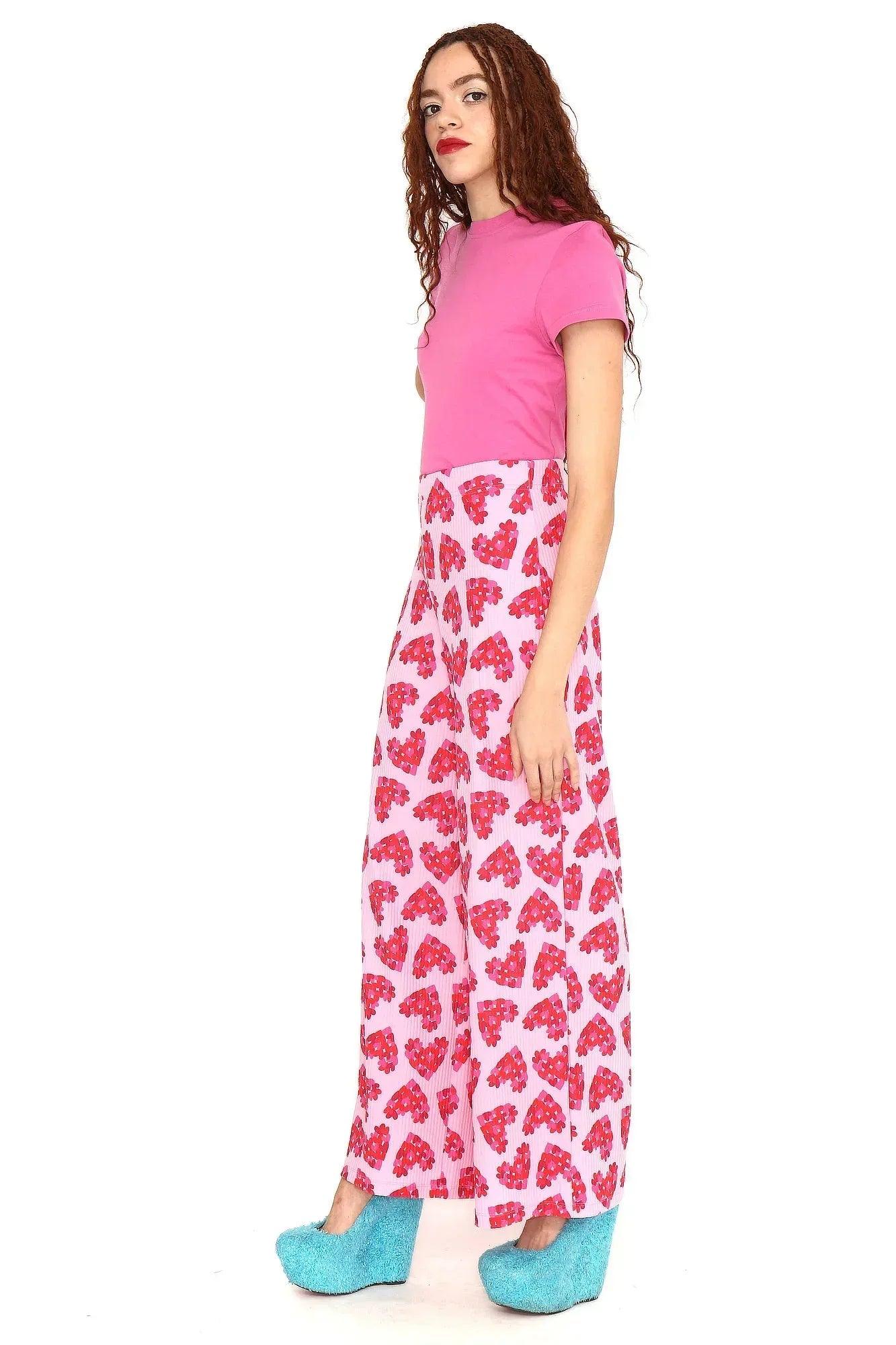 Pantalón estampado de corazones rojo sobre fondo rosa, corte amplio