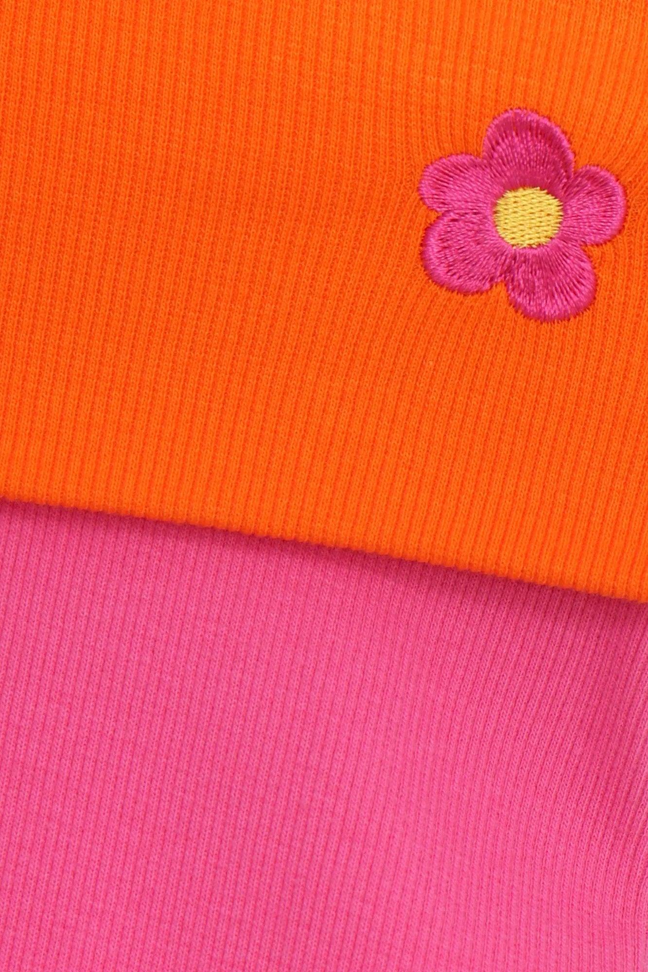 Tela de punto naranja y rosa con flor bordada morada y detalle amarillo