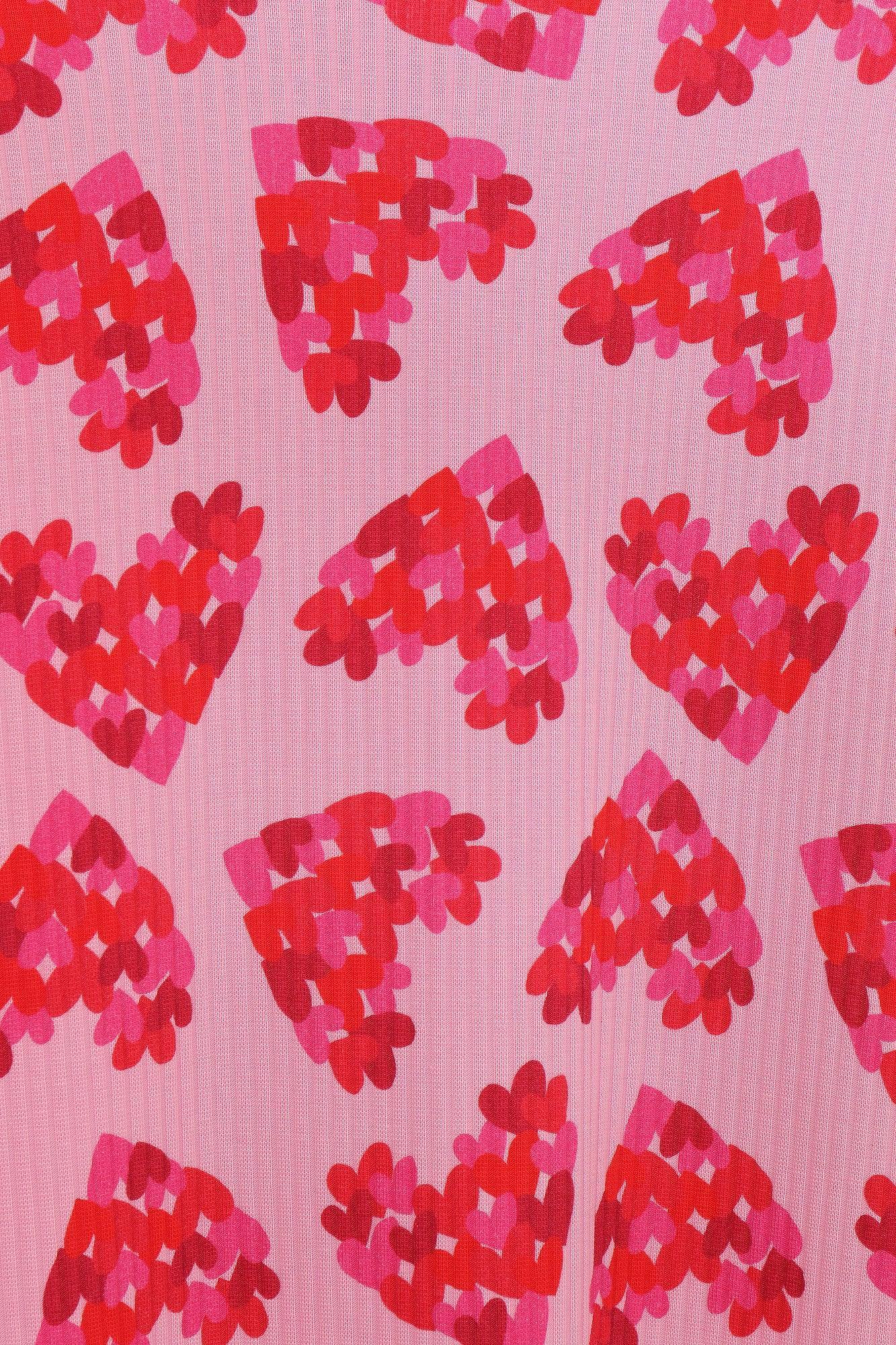 Tejido del vestido con corazones estampados en rosa claro y rojo