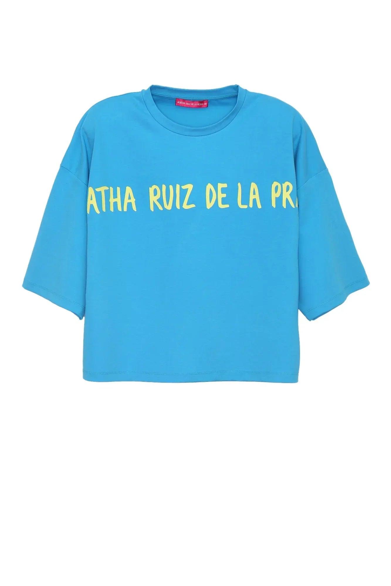 Camiseta oversize turquesa con texto amarillo parcial en el pecho y cuello redondo