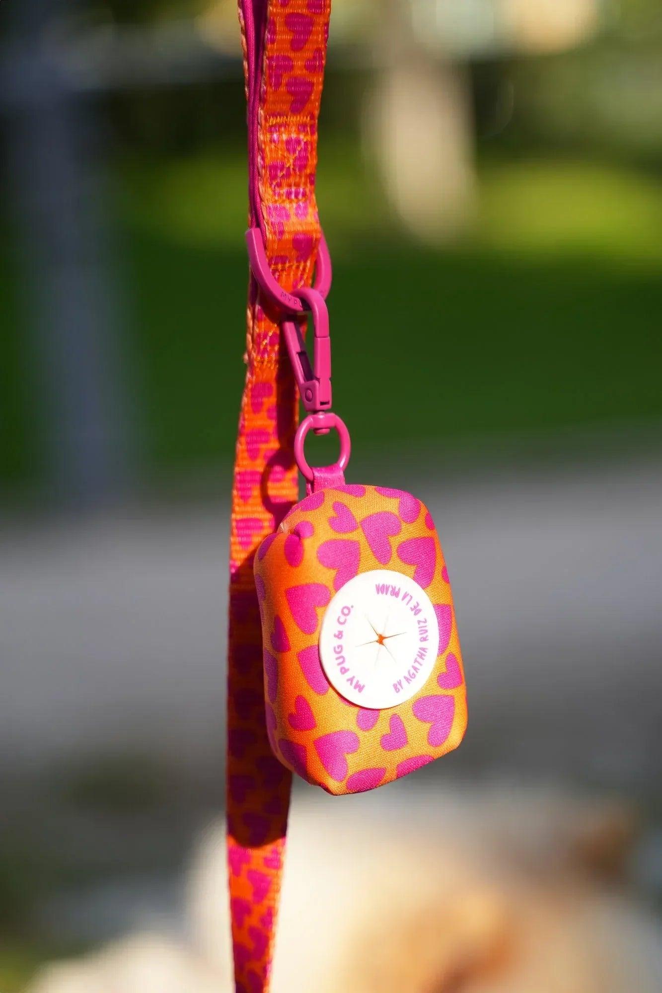 Porta bolsas de tela con corazones, con correa fucsia y mosquetón