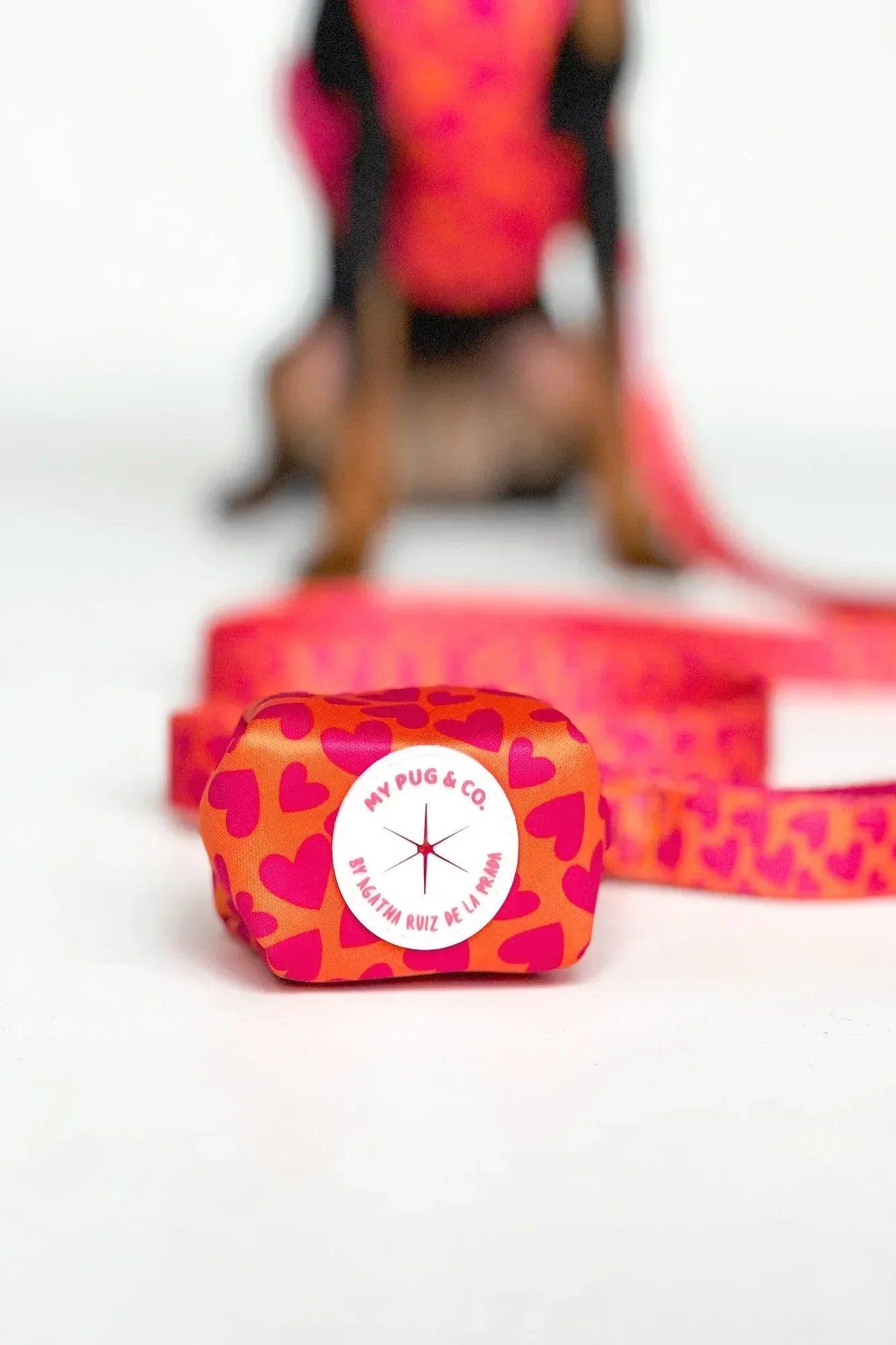 Porta bolsas de tela con estampado de corazones, con etiqueta circular