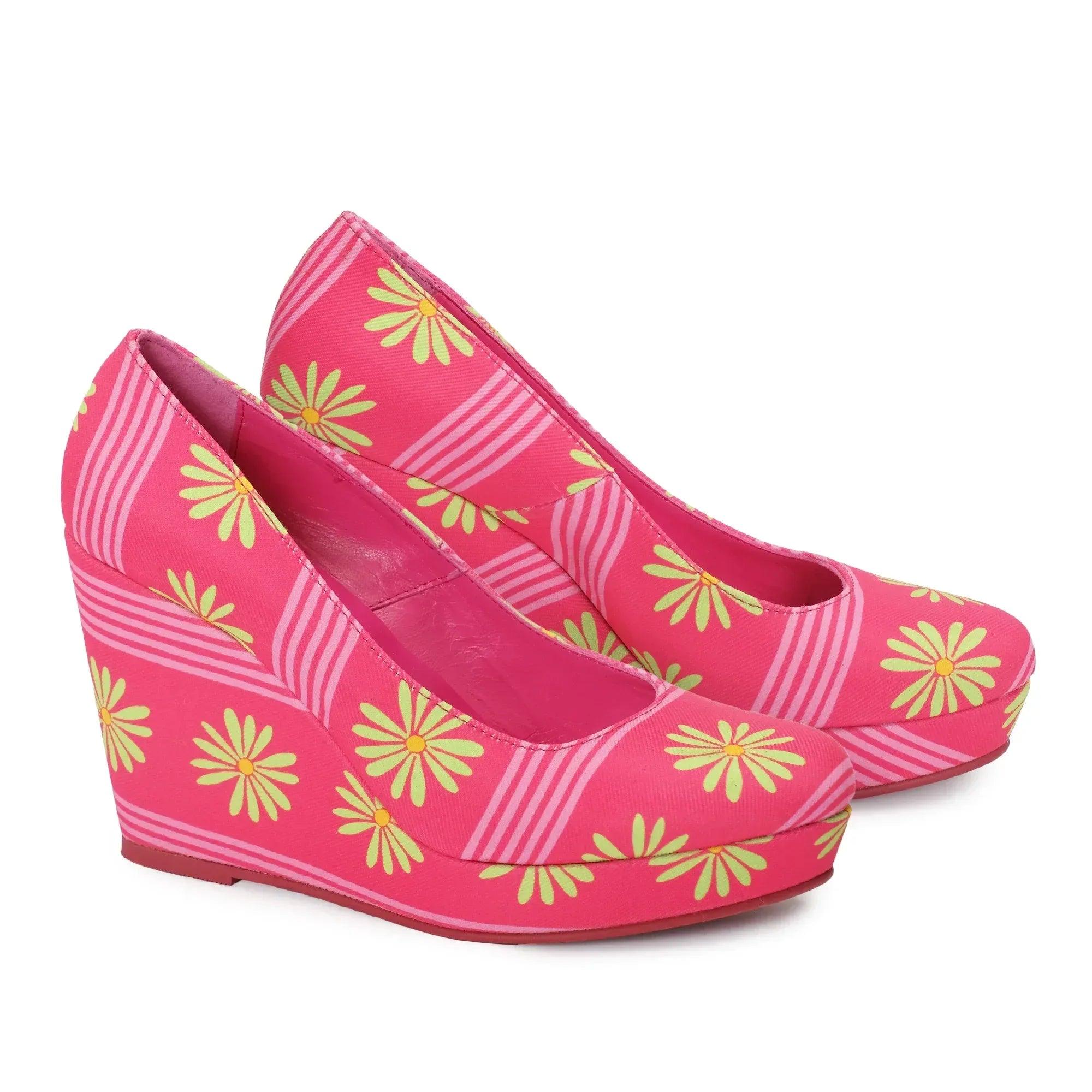 Zapatos de cuña fucsia con estampado de margaritas amarillas y rayas rosadas.