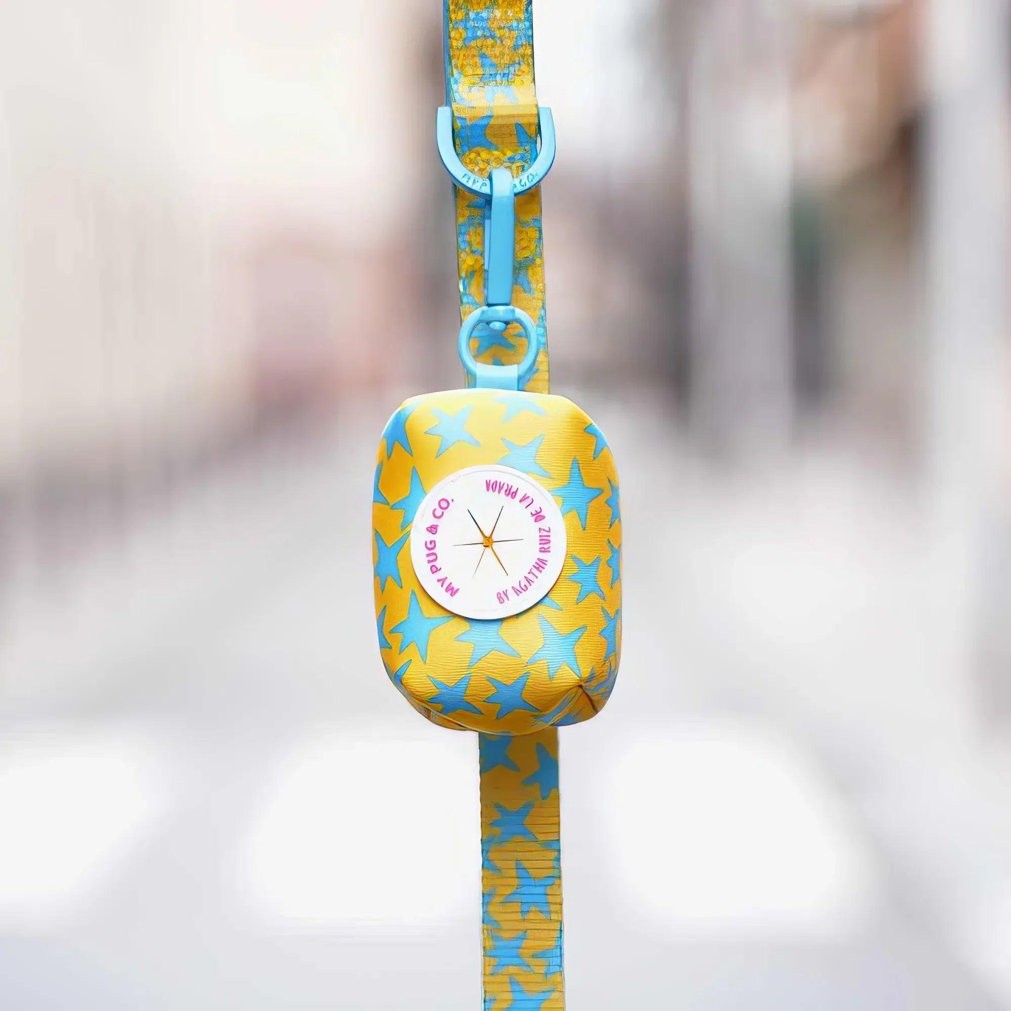 Porta bolsas de tela amarillo con estrellas azules y correa colgante