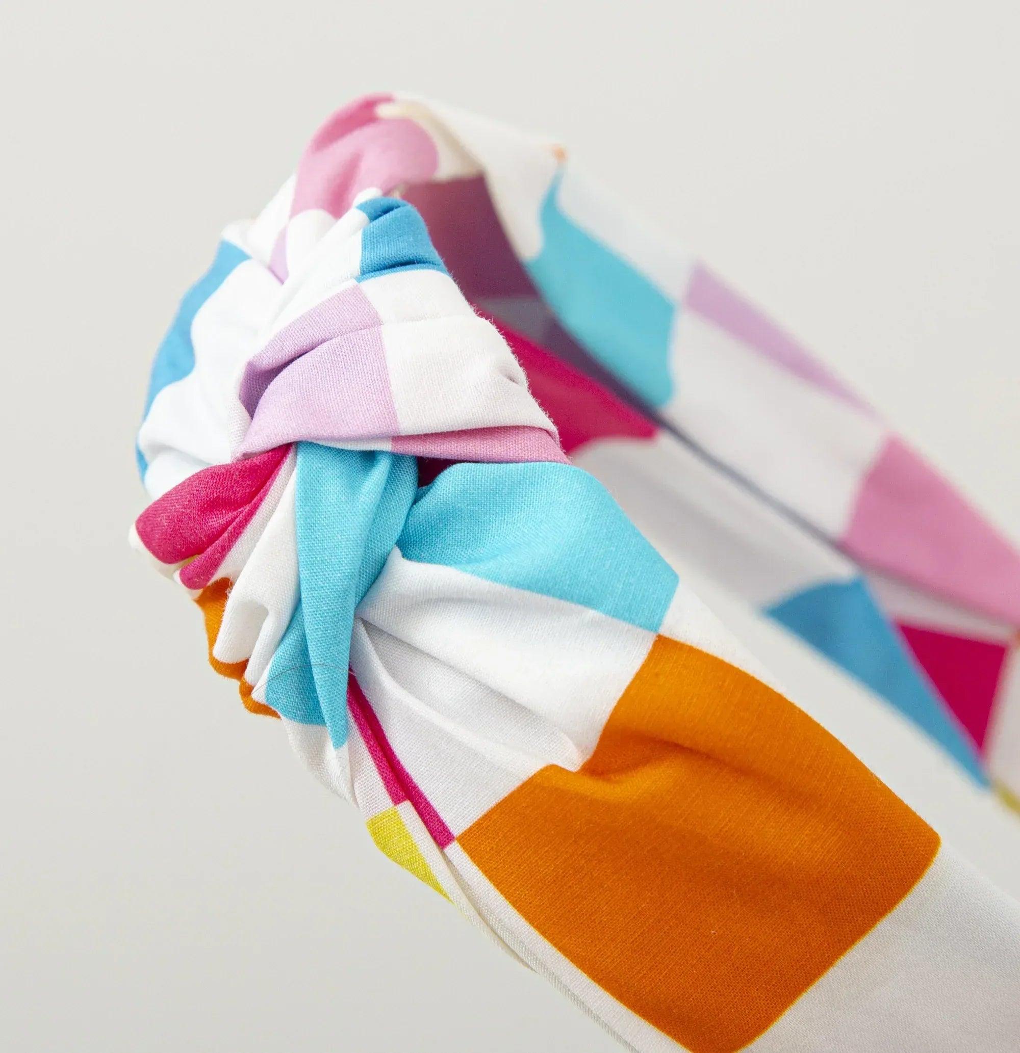 Diadema multicolor con nudo lateral de tela a rayas, tonos rosa, azul y naranja