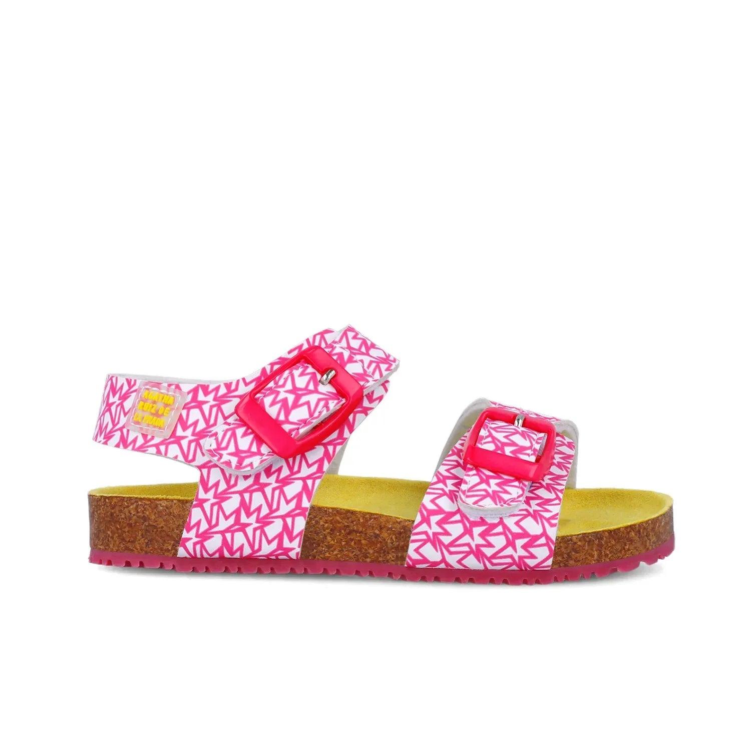 Sandalias fucsia con tira en el empeine y hebilla roja; suela de corcho.