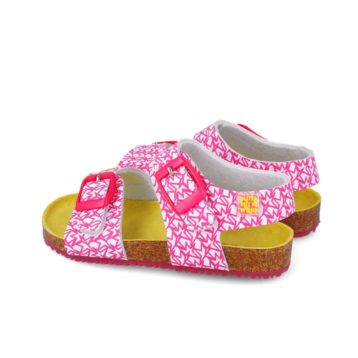 Sandalias fucsia con dos tiras cruzadas, hebillas rojas y suela de corcho.