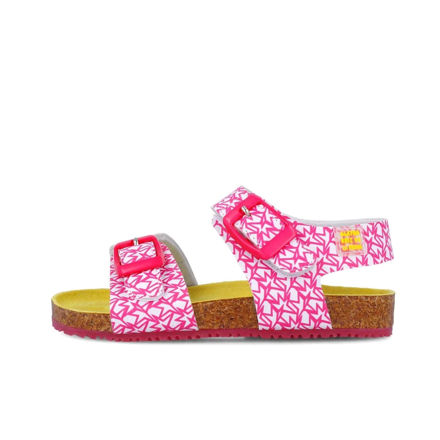 Sandalias fucsia con dos correas y hebillas rojas; suela de corcho con plataforma.