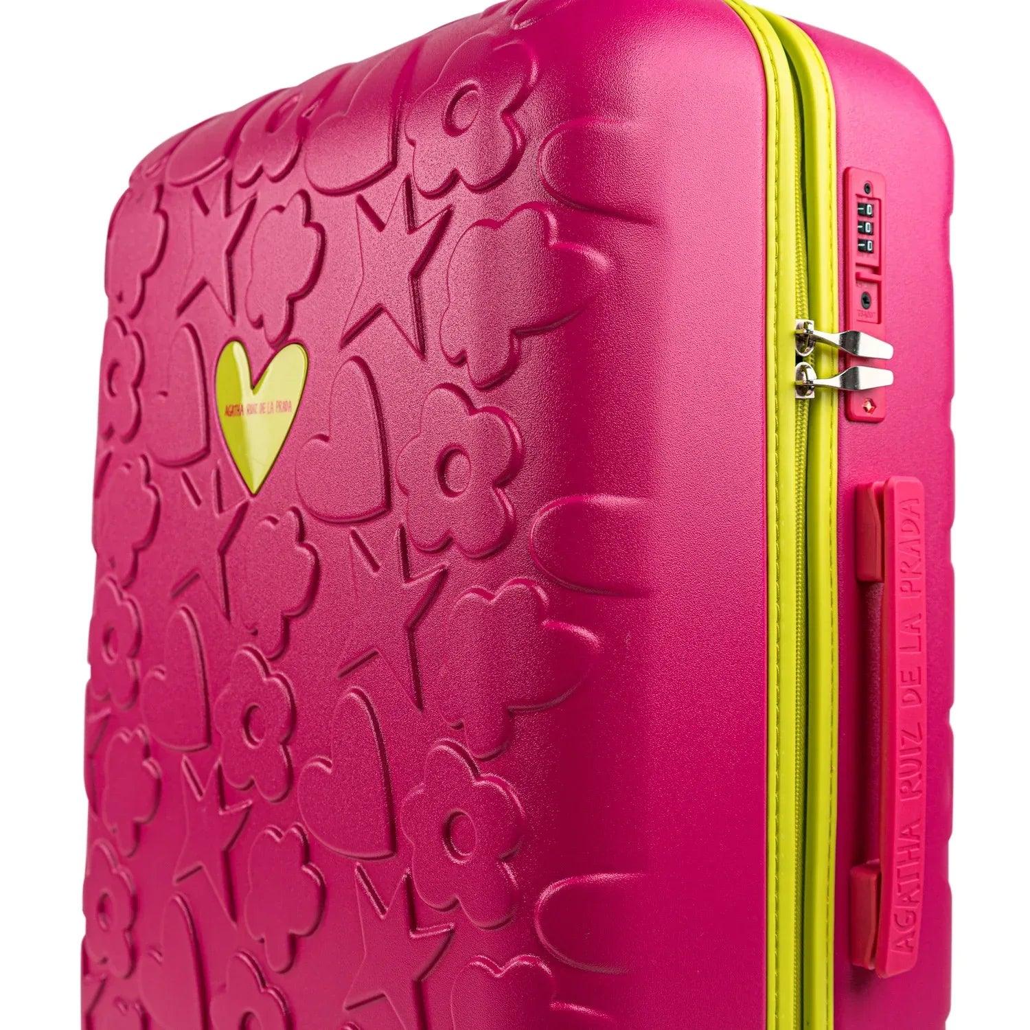 Maleta trolley fucsia con textura de motivos y cierre lateral en color verde.