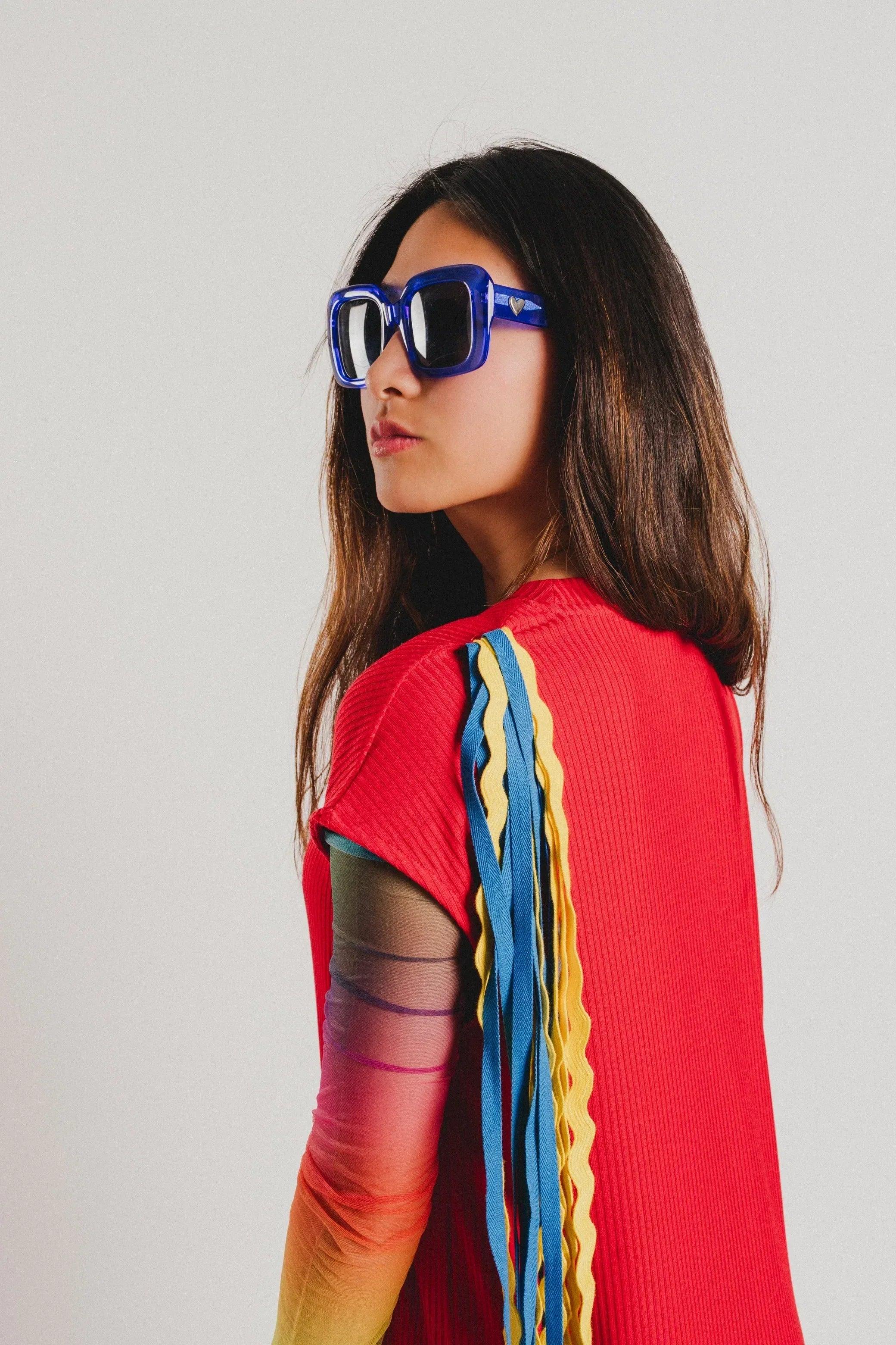 Vestido rojo con cuello alto y manga acampanada; franja multicolor en el lateral
