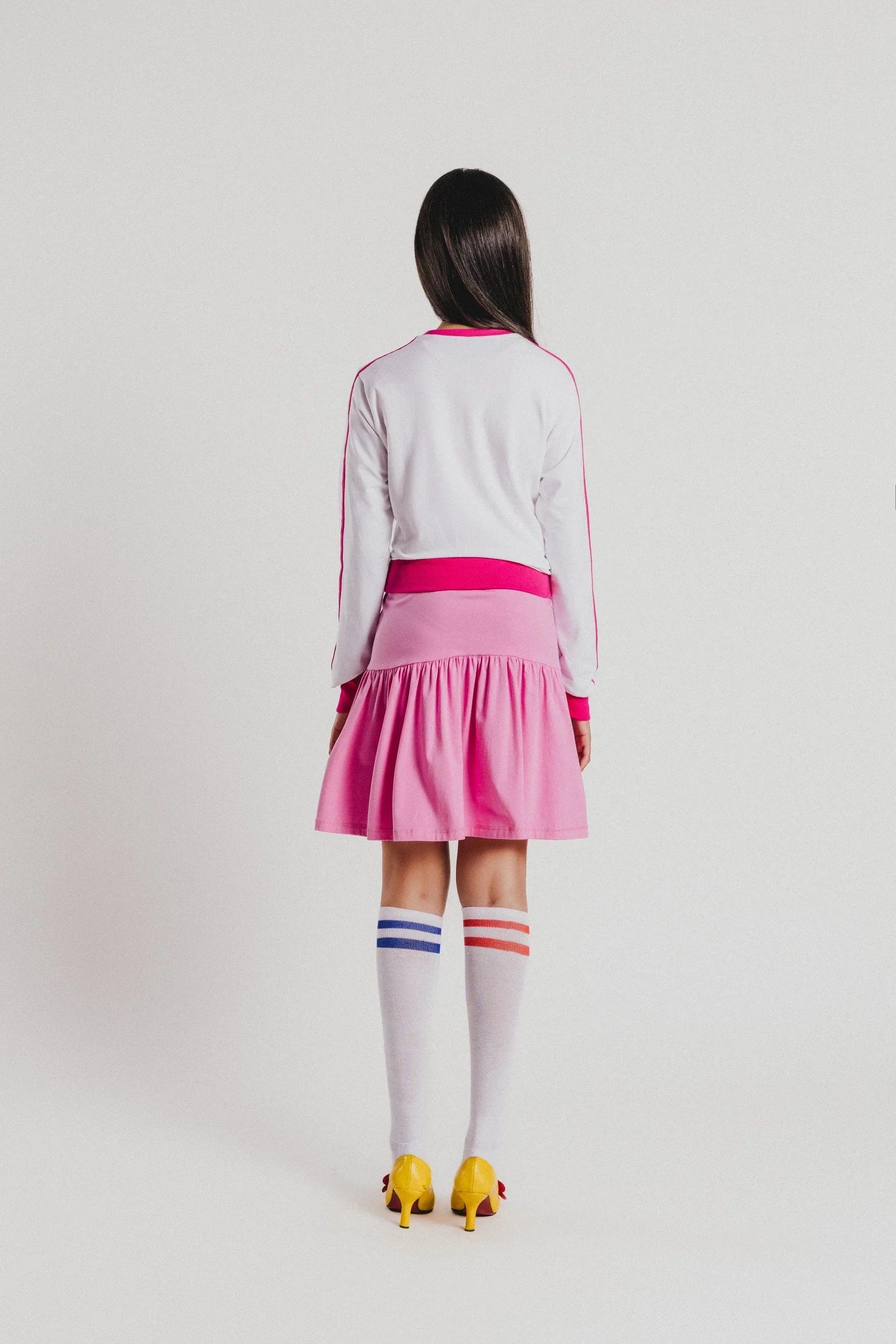Sudadera blanca con ribete fucsia en el dobladillo y falda rosa estampada floral