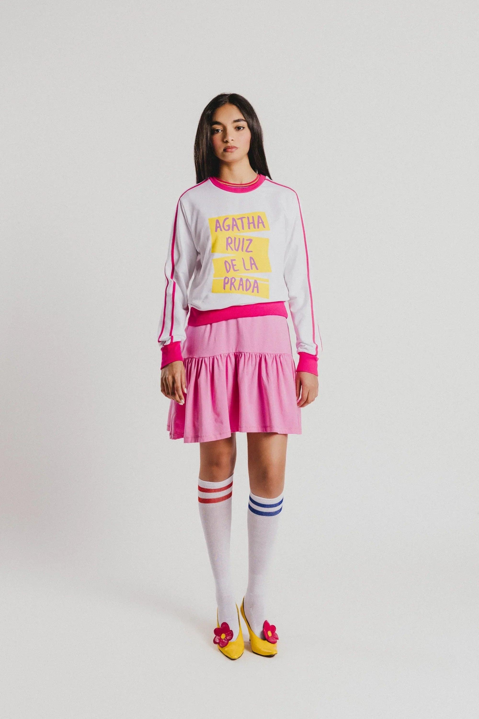 Sudadera blanca con ribete fucsia, falda rosa estampada floral y calcetines a rayas