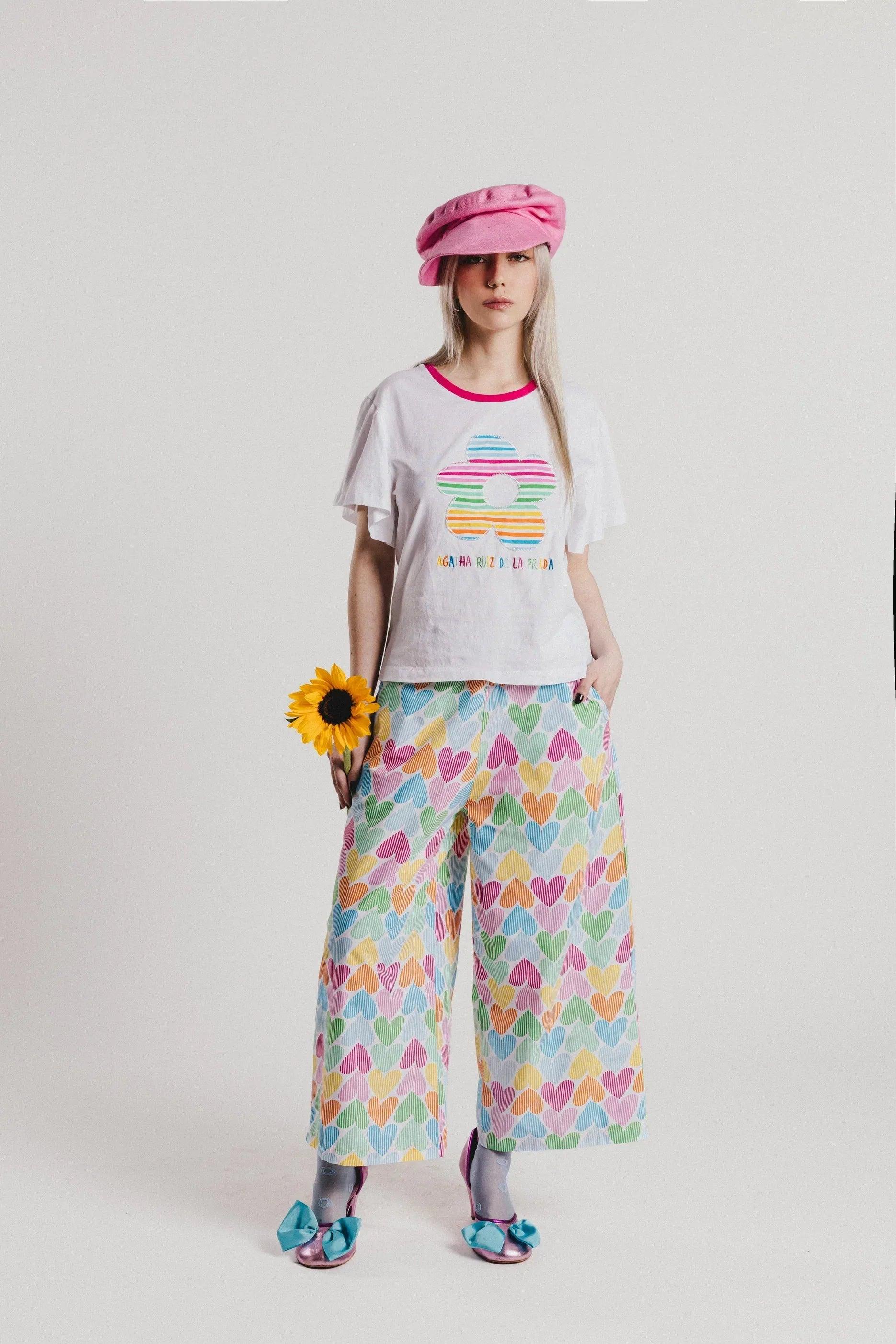 Camiseta blanca infantil con cuello rosa y flor multicolor con rayas arcoíris