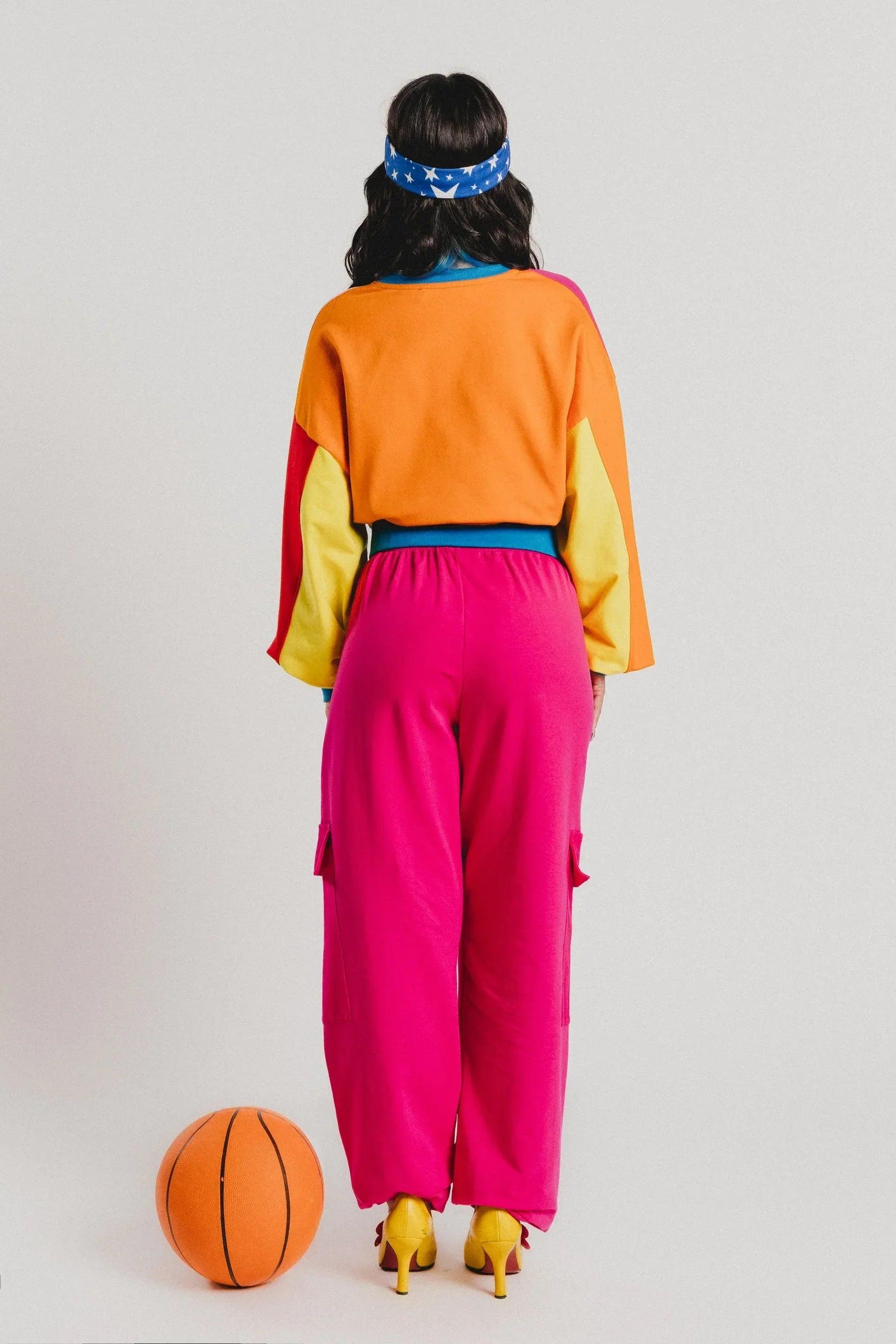 Pantalón cargo fucsia por detrás, dobladillo holgado y bolsillos tipo parche.