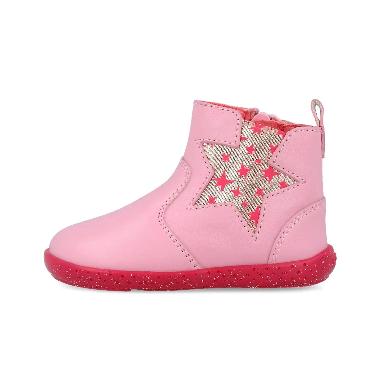 Bota rosa con estrella grande de colores en el empeine y suela roja moteada.