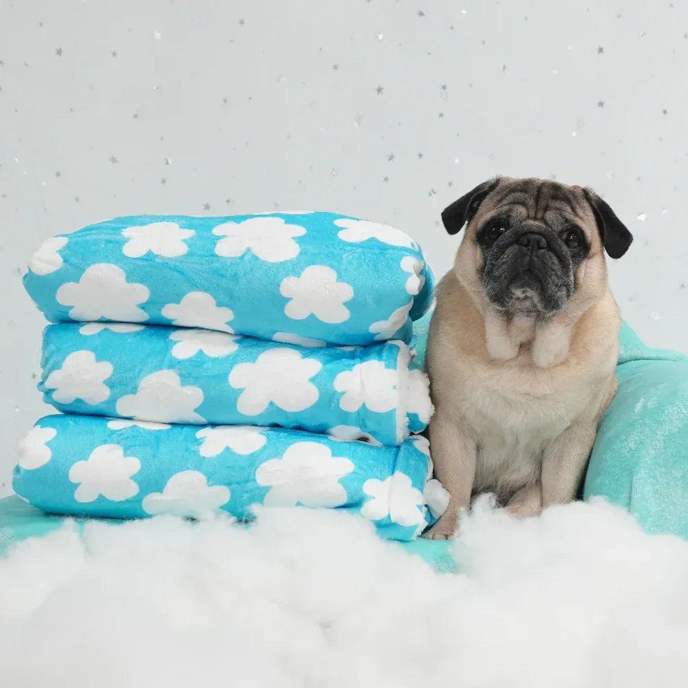 Manta para perro azul con estampado de nubes blancas y tacto suave.