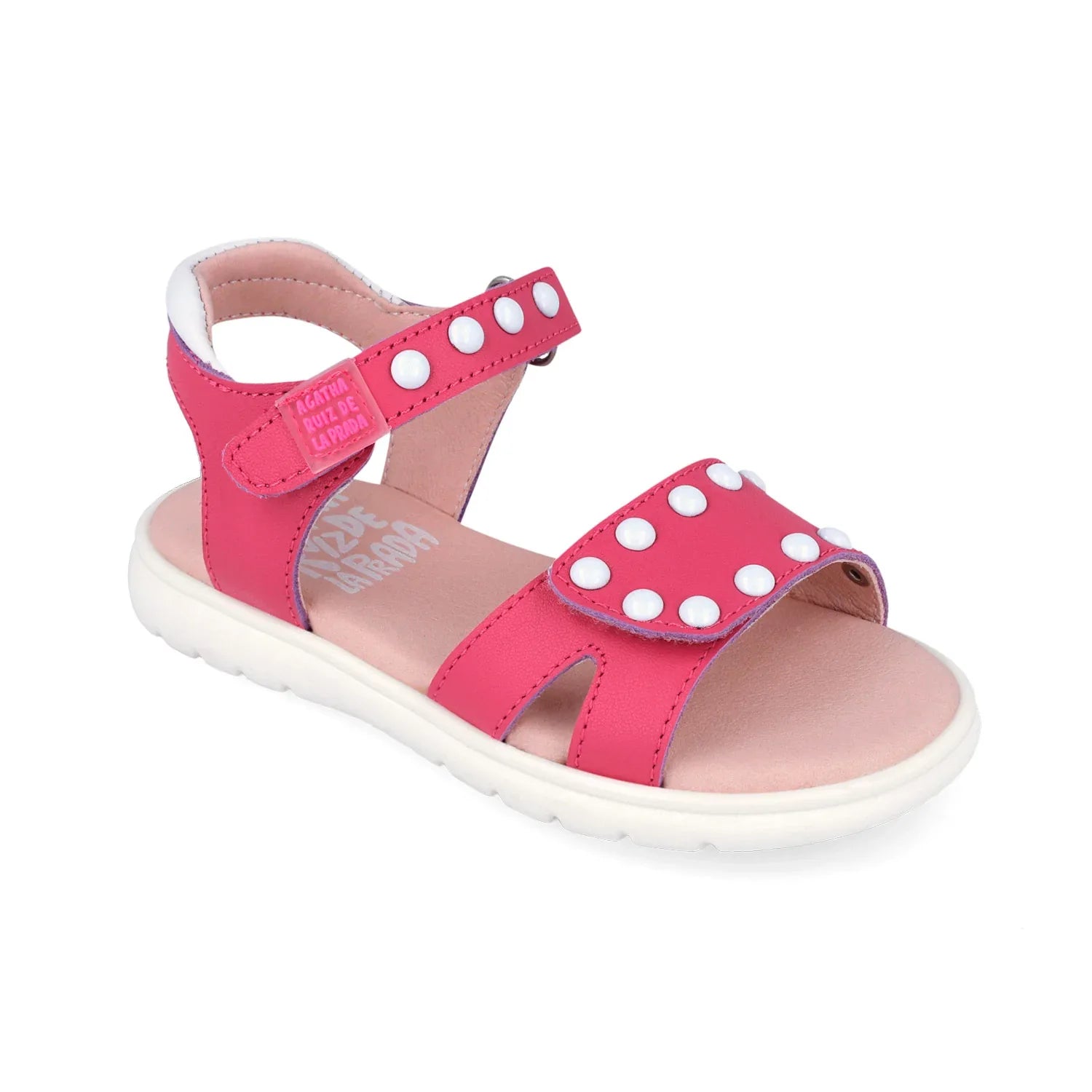 Sandalias rosas con trabillas delanteras y tachuelas blancas sobre la pala