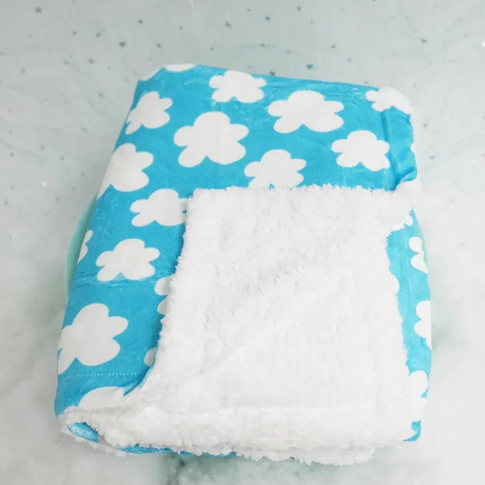 Manta para perro con base blanca de felpa y borde azul con nubes.