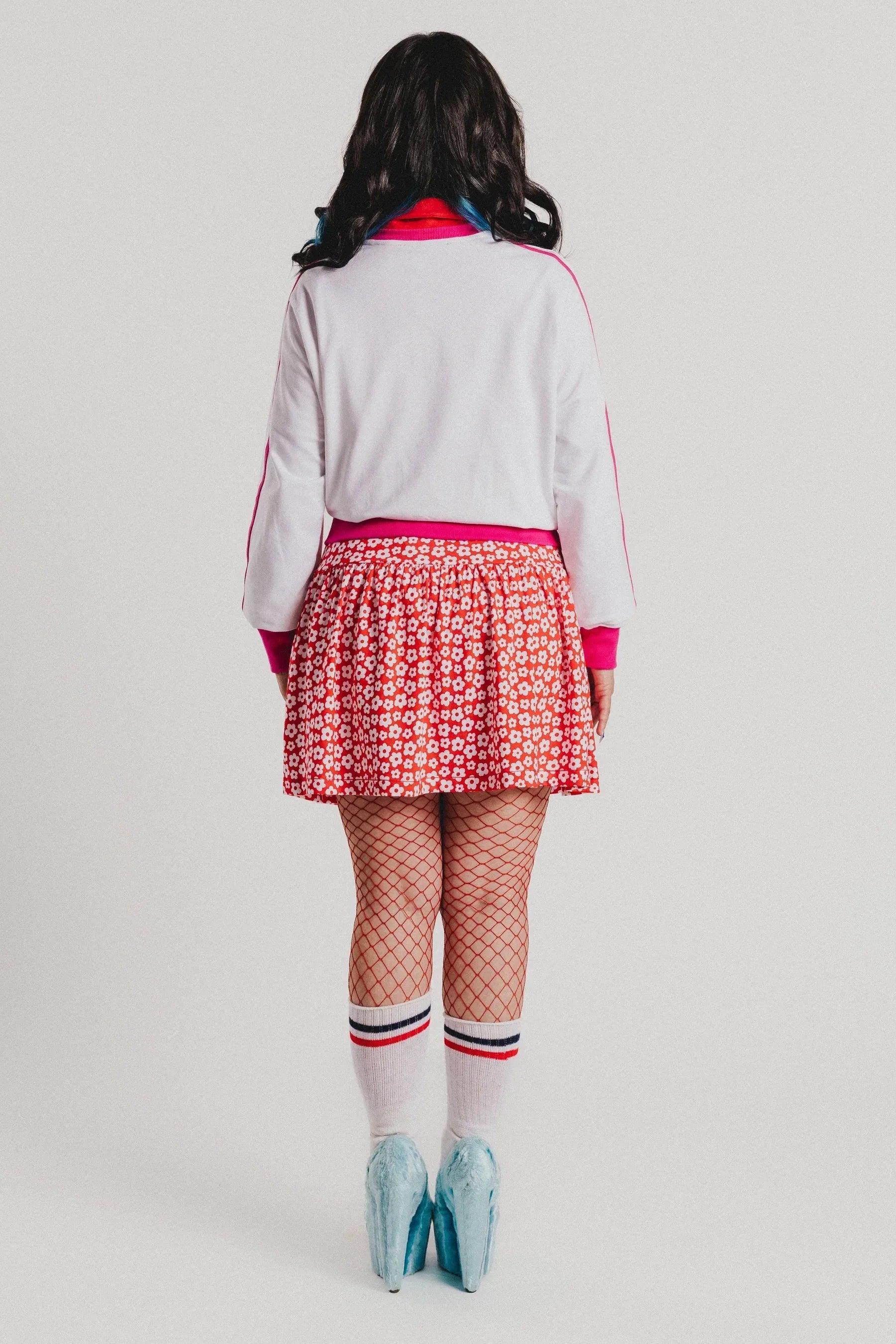 Sudadera blanca vista trasera con ribete fucsia y falda roja de flores