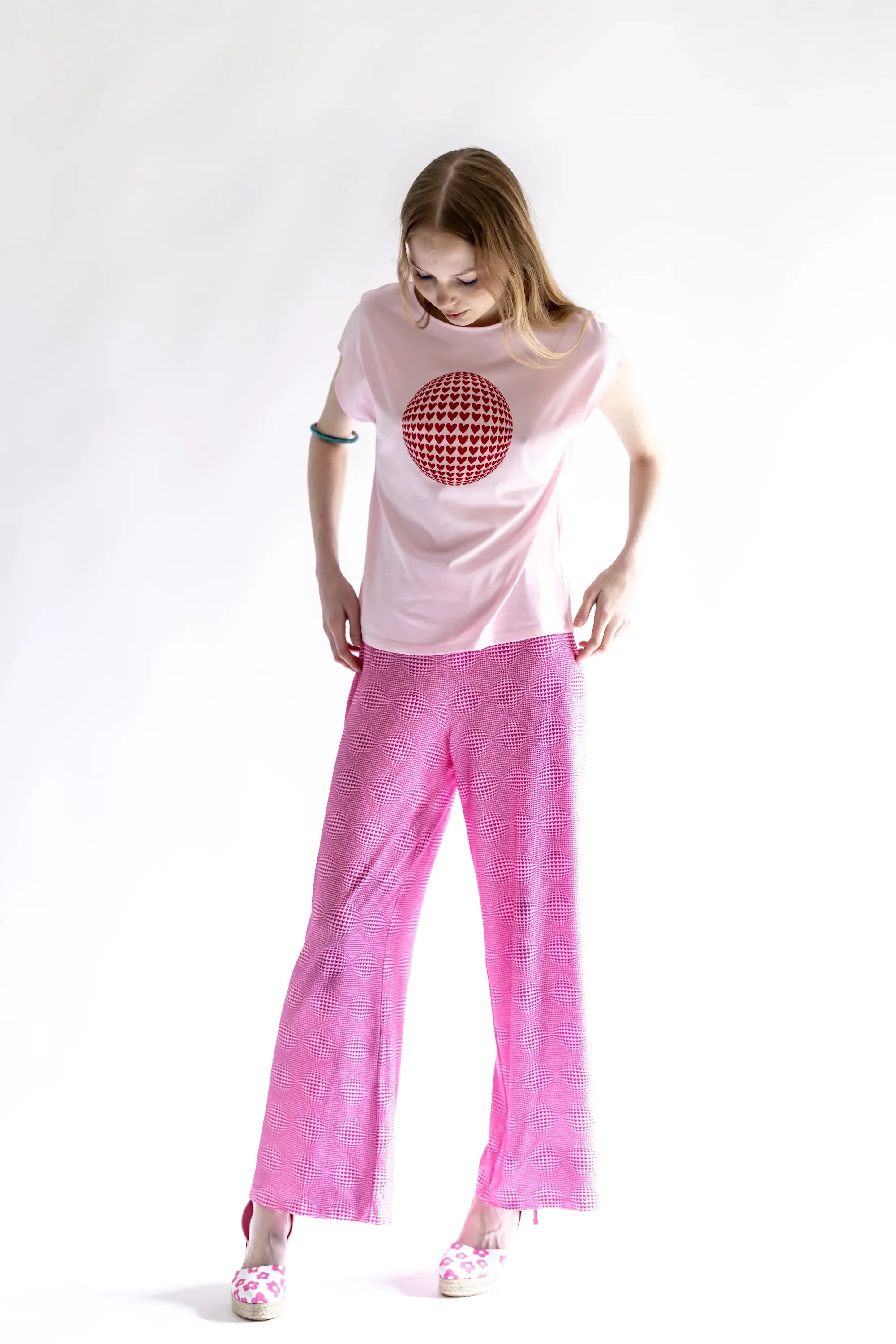 Pantalón rosa de pierna ancha con estampado de corazones en todo el tejido.