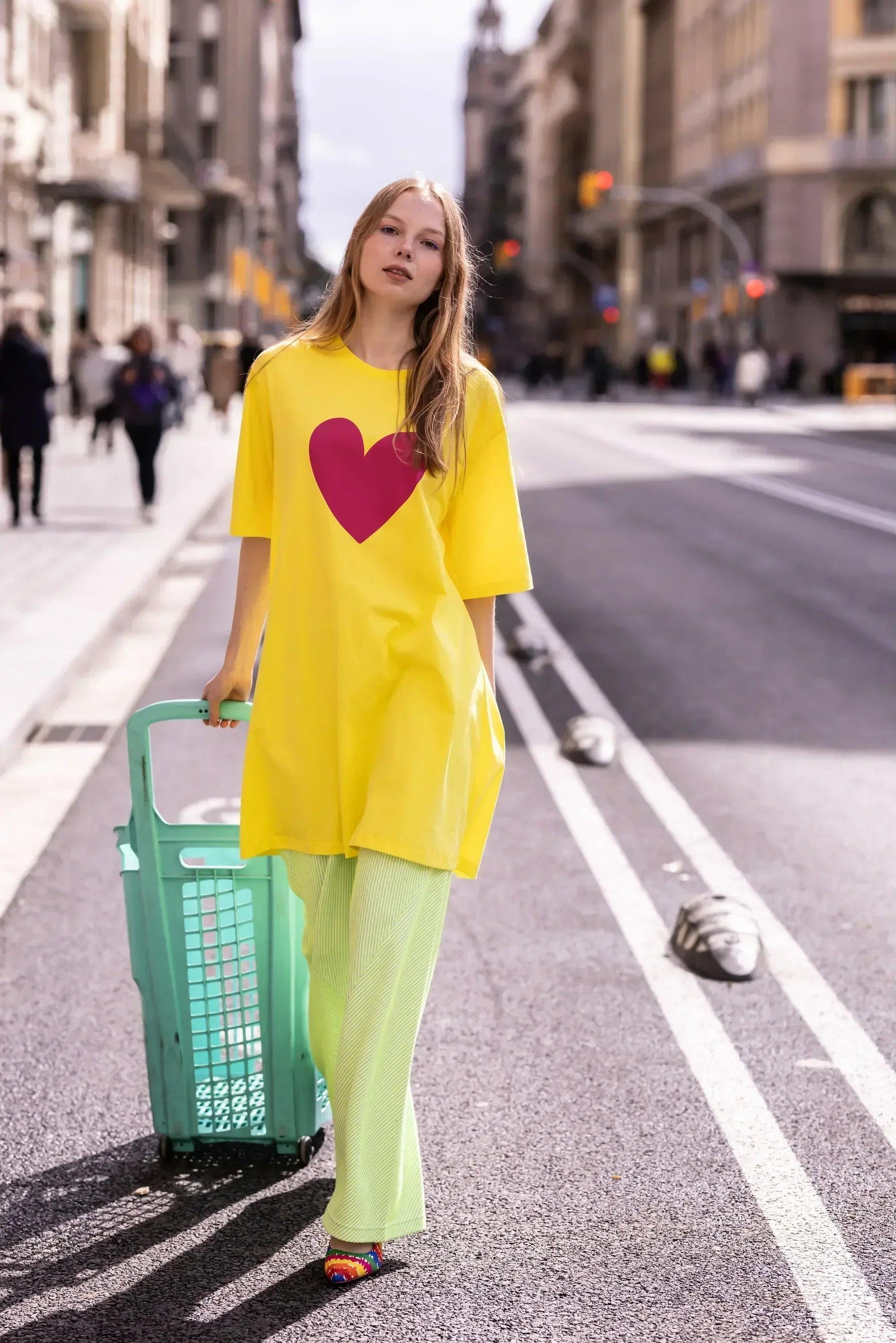 Vestido amarillo con corazón fucsia, manga corta y lleva pantalón a juego