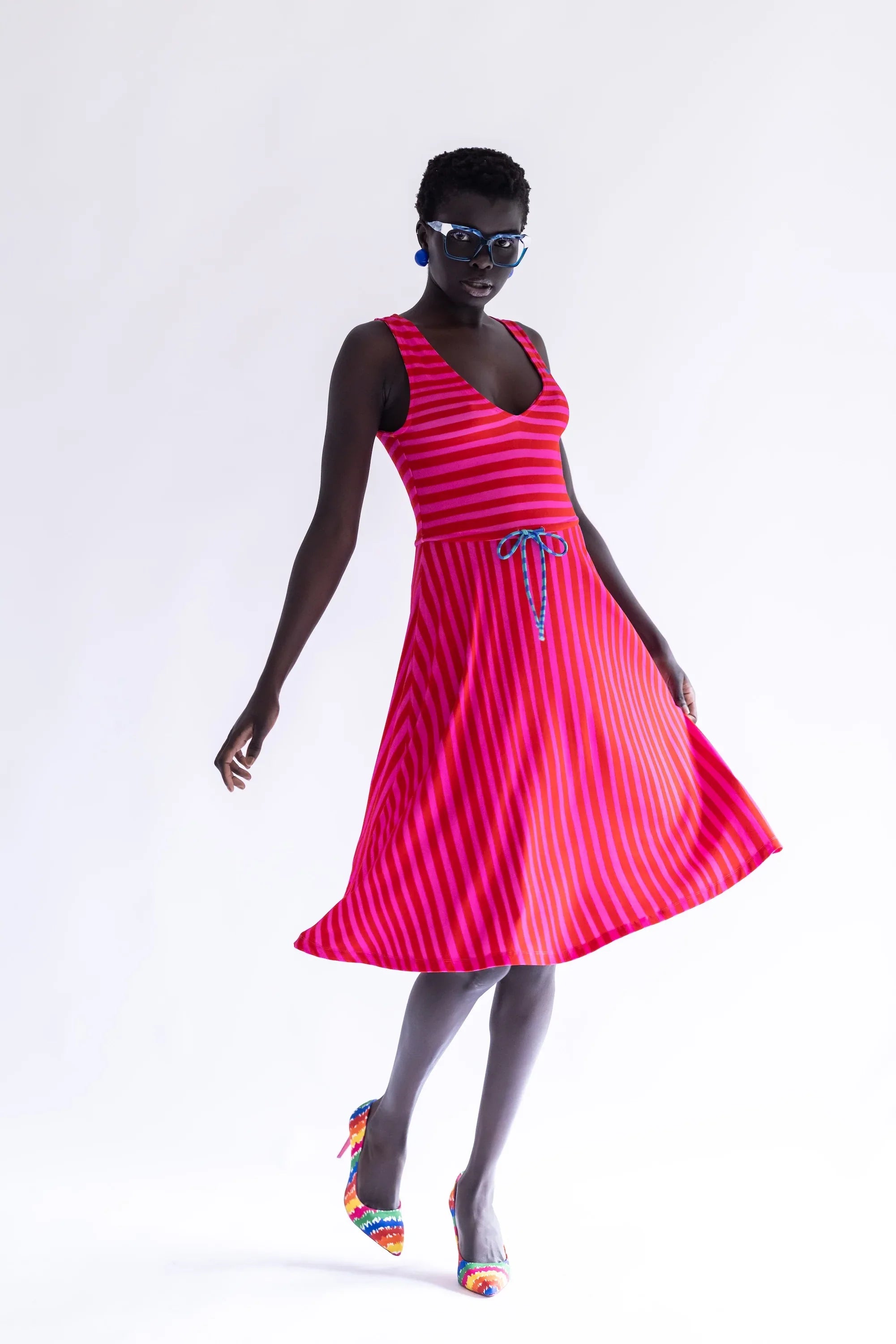 Vestido sin mangas rayado fucsia y rojo con escote V y falda amplia.