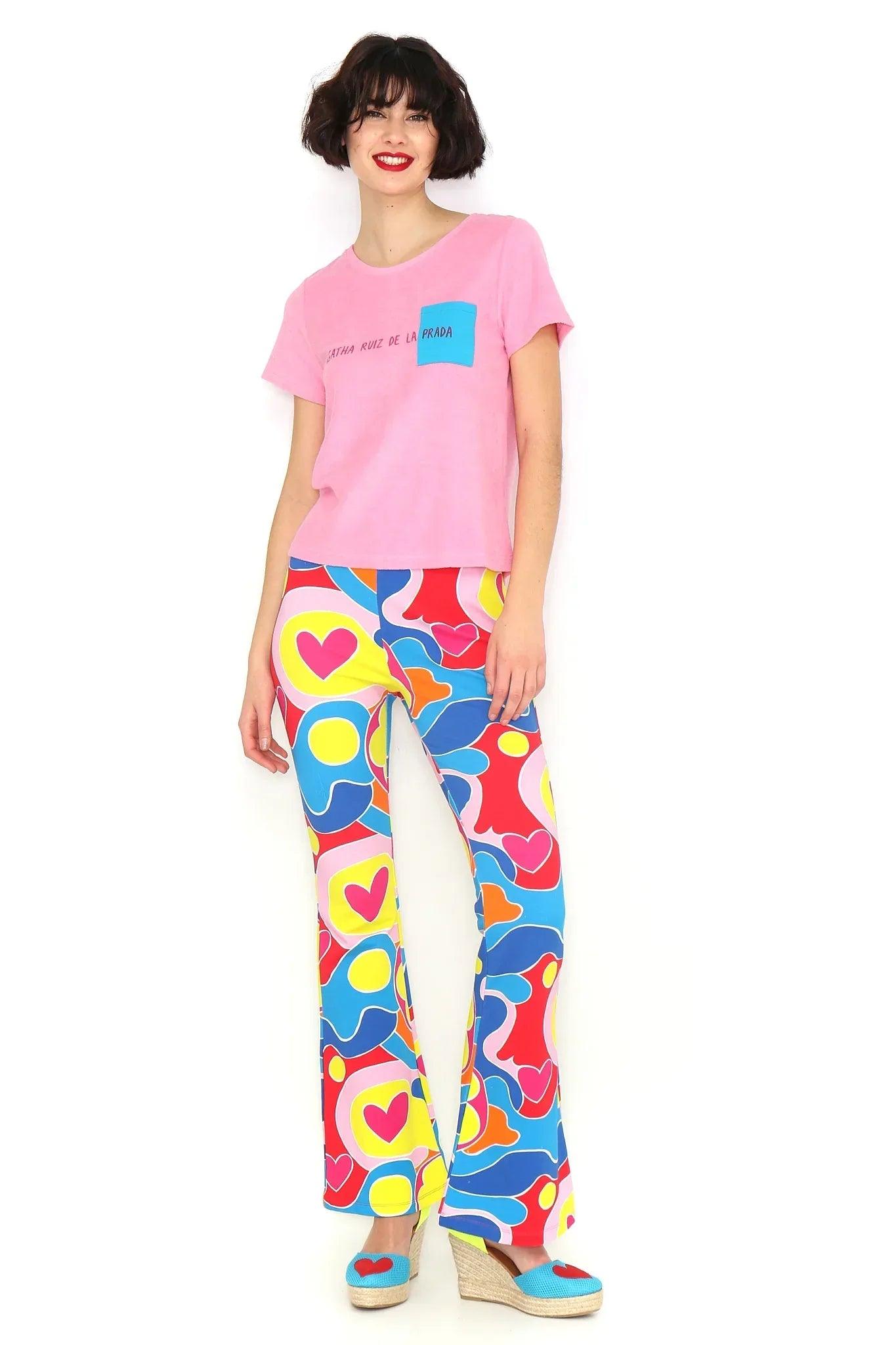 Camiseta rosa con bolsillo azul y estampado pequeño en el pecho, manga corta.